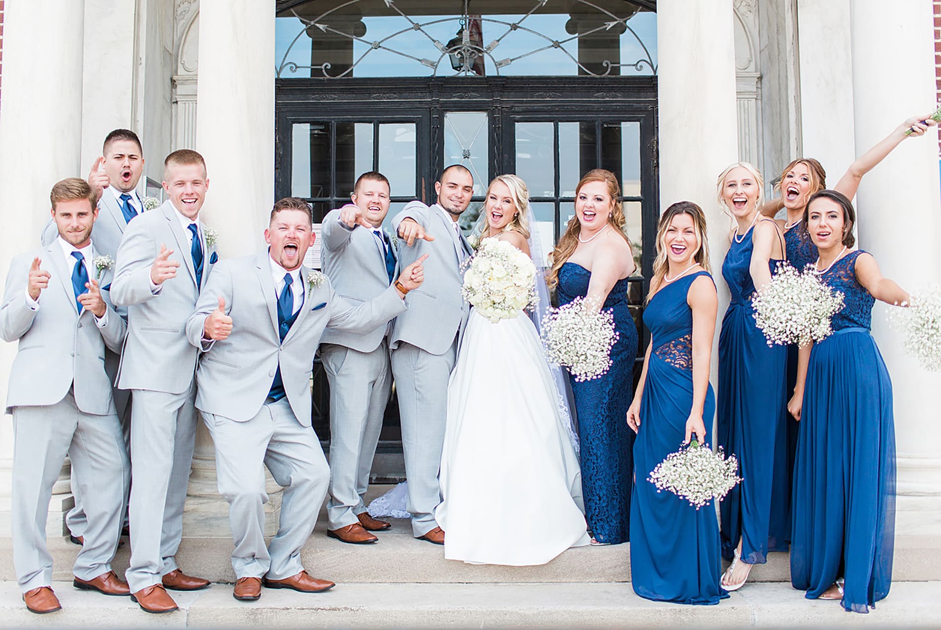 Arielle Peters Photography | Wedding party cheering next to limestone building on wedding day at the Freemasons Hall in Fort Wayne, Indiana.