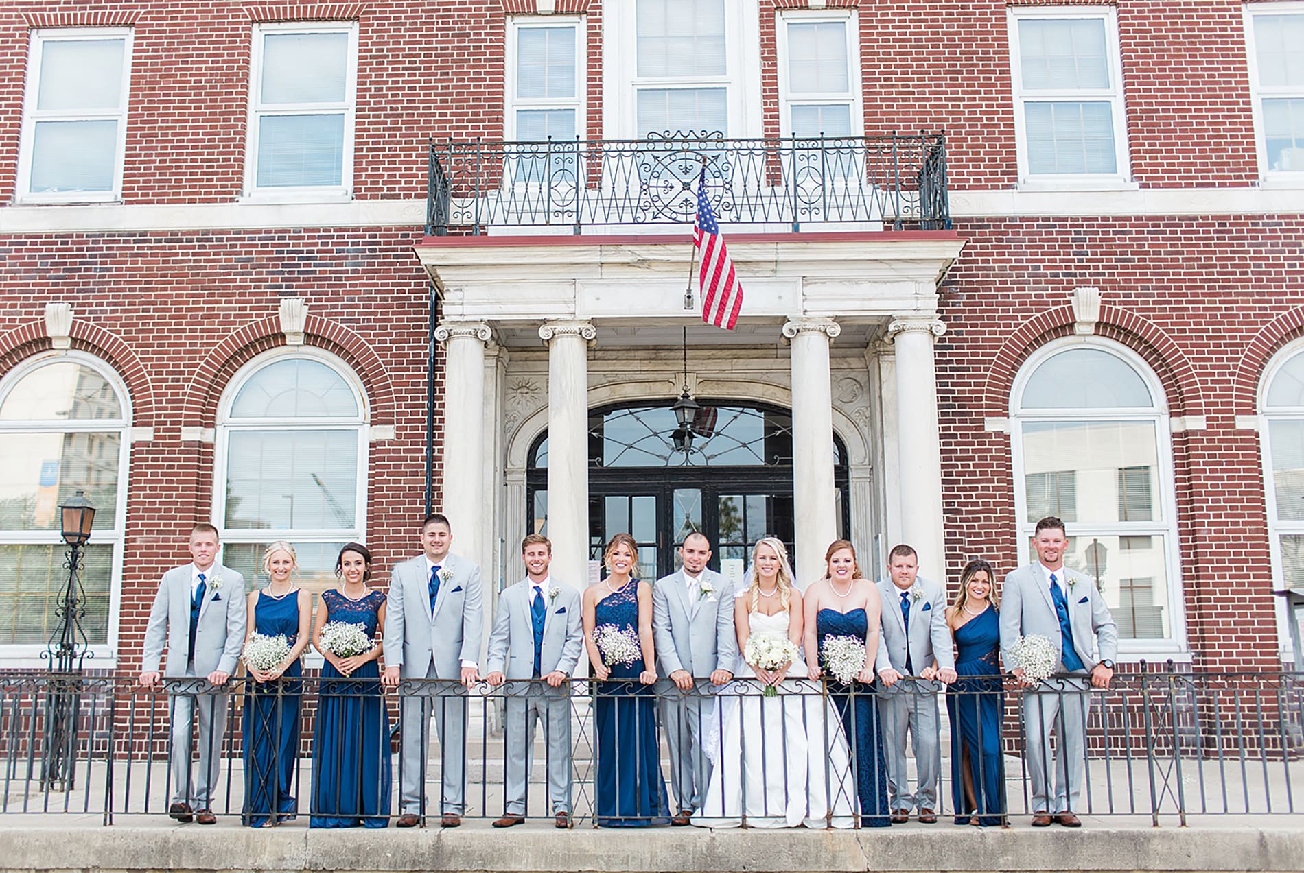 Arielle Peters Photography | Wedding party leaning against iron railing on wedding day at the Freemasons Hall in Fort Wayne, Indiana.