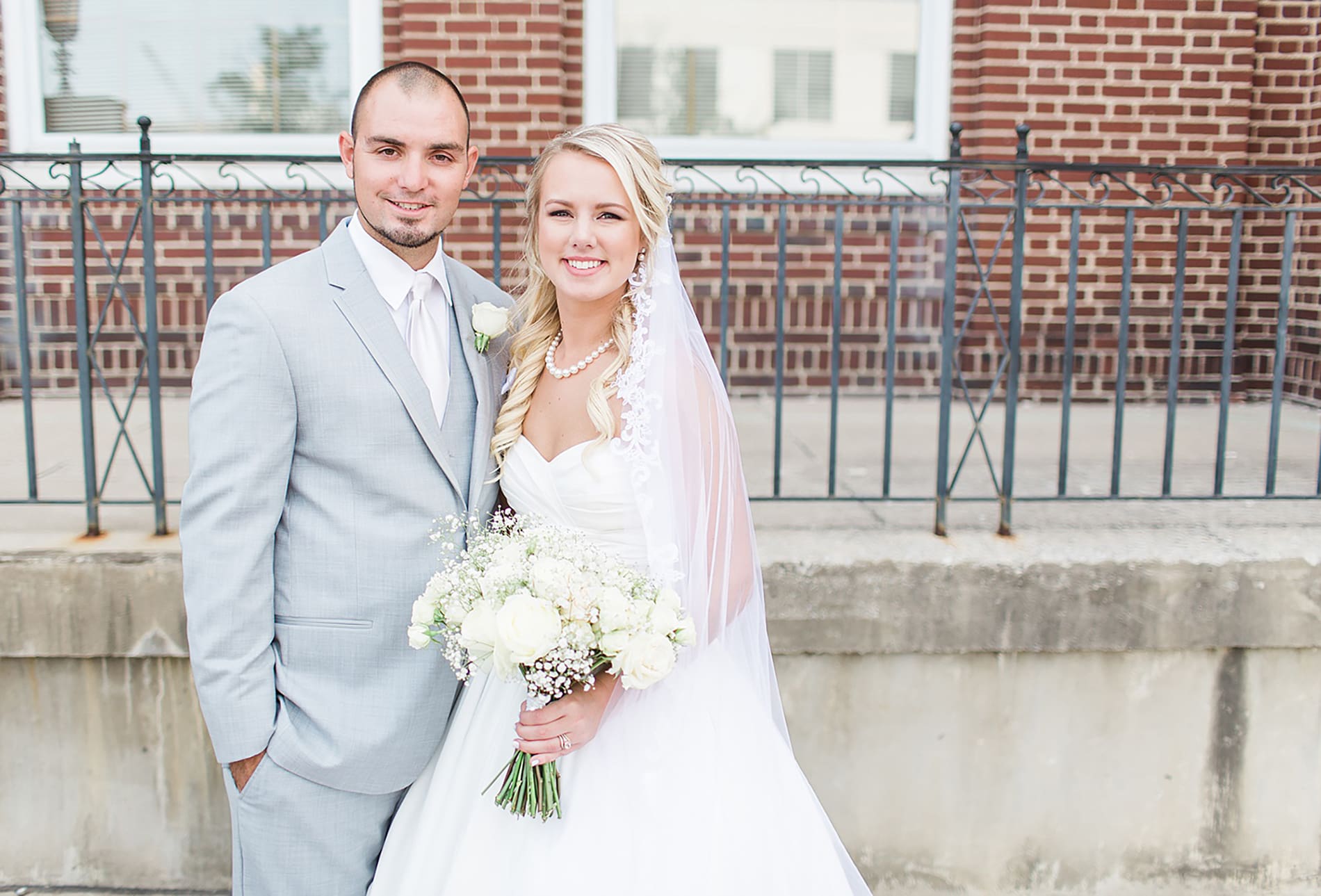 Arielle Peters Photography | Bride and groom next to red brick building on wedding day at the Freemasons Hall in Fort Wayne, Indiana.