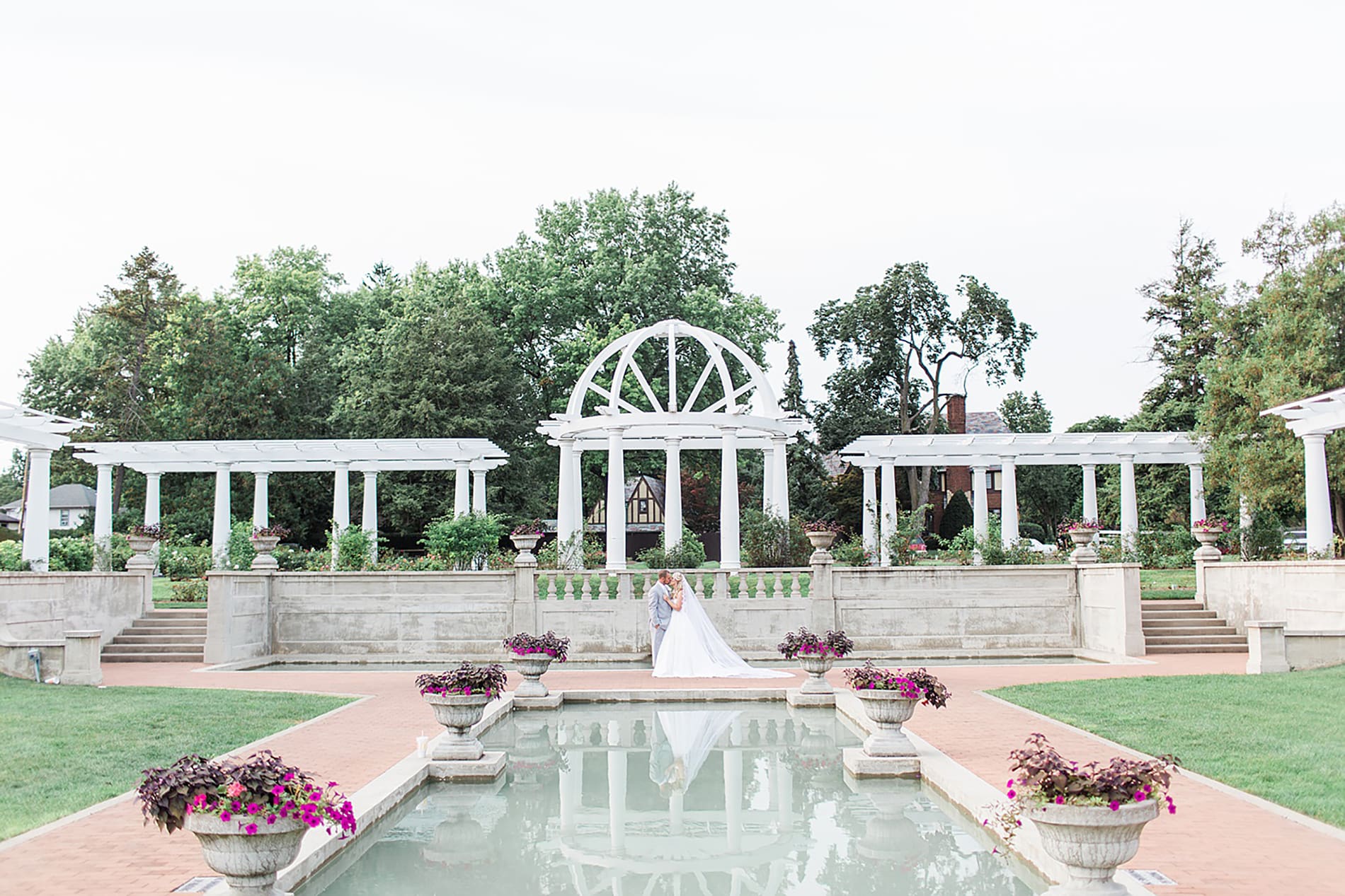 Arielle Peters Photography | Bride and groom in overgrown rose garden next to reflection pool on wedding day at the Freemasons Hall in Fort Wayne, Indiana.