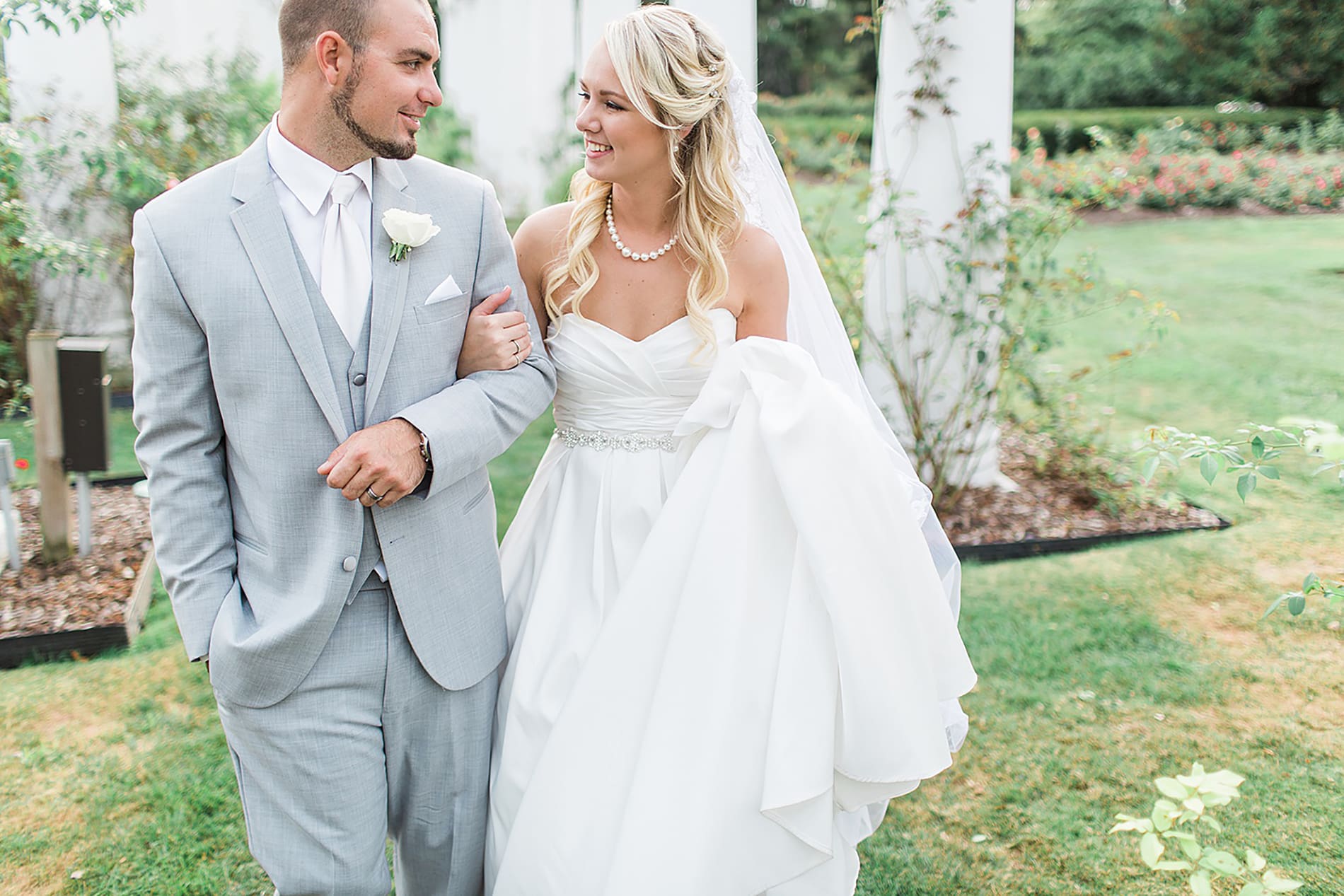 Arielle Peters Photography | Bride and groom walking in rose garden on wedding day at the Freemasons Hall in Fort Wayne, Indiana.