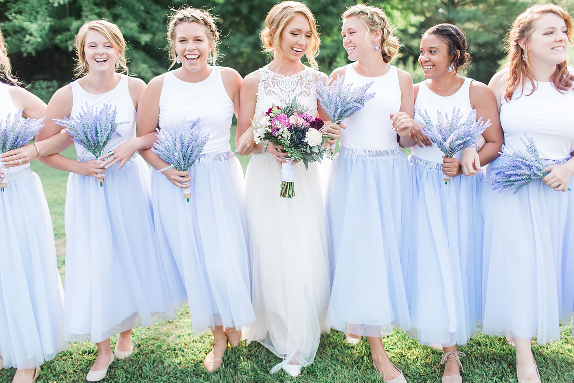 Arielle Peters Photography | Bride and bridesmaids walking holding lavender bouquets on wedding day at Willowfield Lavender Farm in Mooresville, Indiana. 