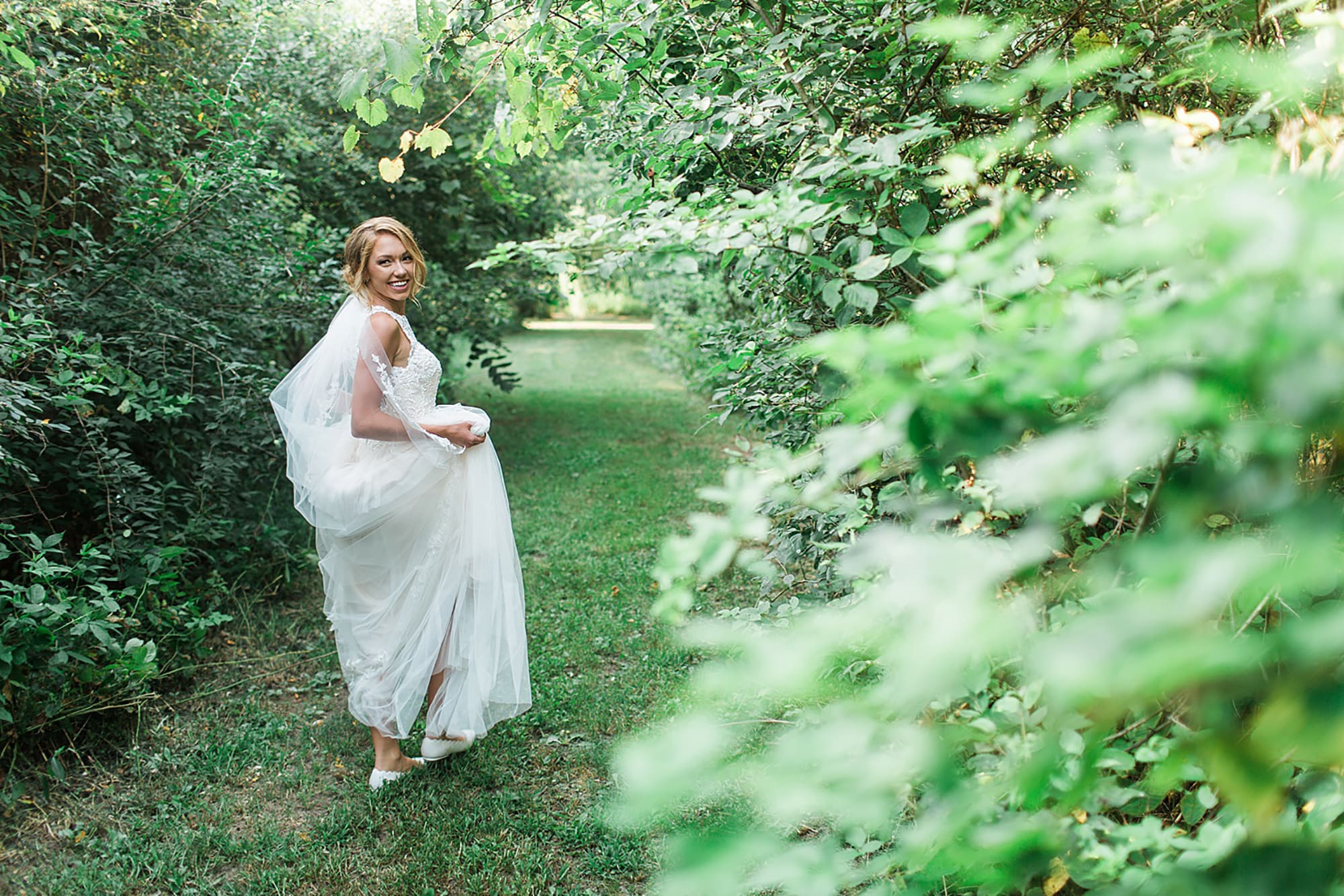 Arielle Peters Photography | Bride walking through tunnel of trees on wedding day at Willowfield Lavender Farm in Mooresville, Indiana. 