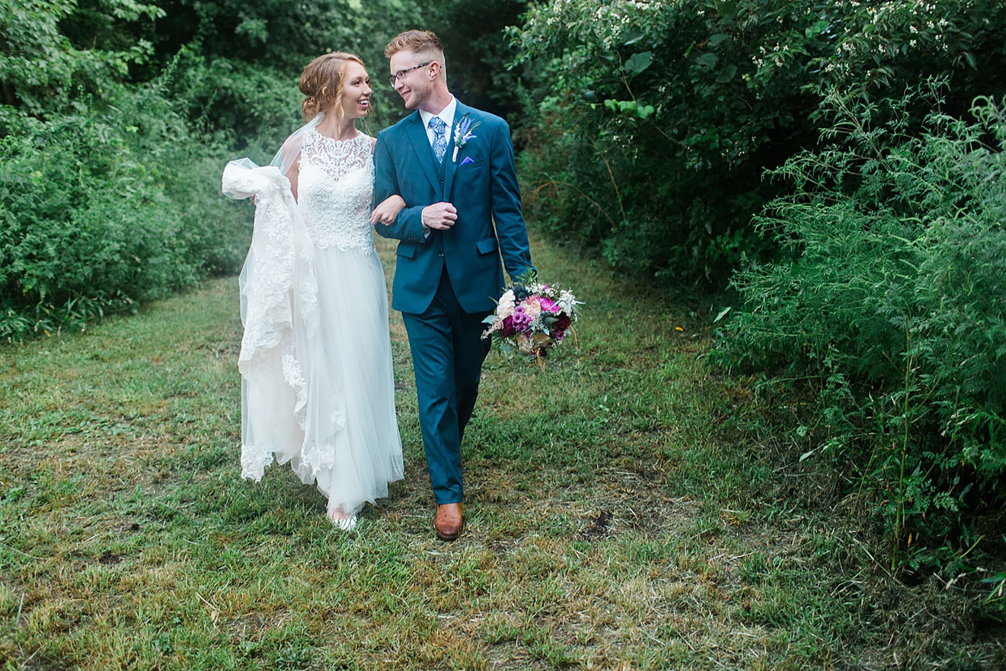 Arielle Peters Photography | Bride and groom walking through tunnel of trees at outdoor wedding at Willowfield Lavender Farm in Mooresville, Indiana. 