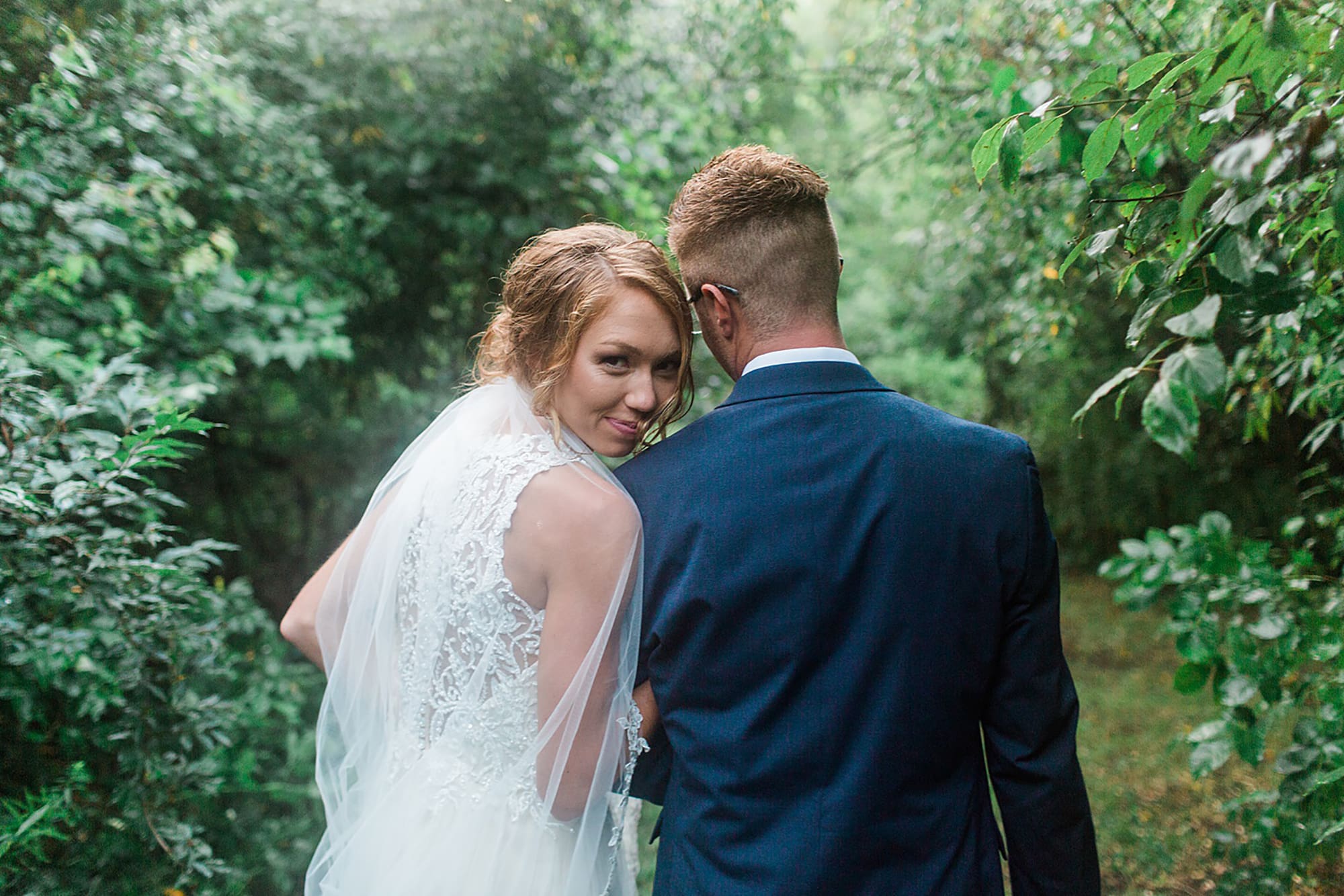 Arielle Peters Photography | Bride and groom walking under tunnel of trees at outdoor wedding at Willowfield Lavender Farm in Mooresville, Indiana. 