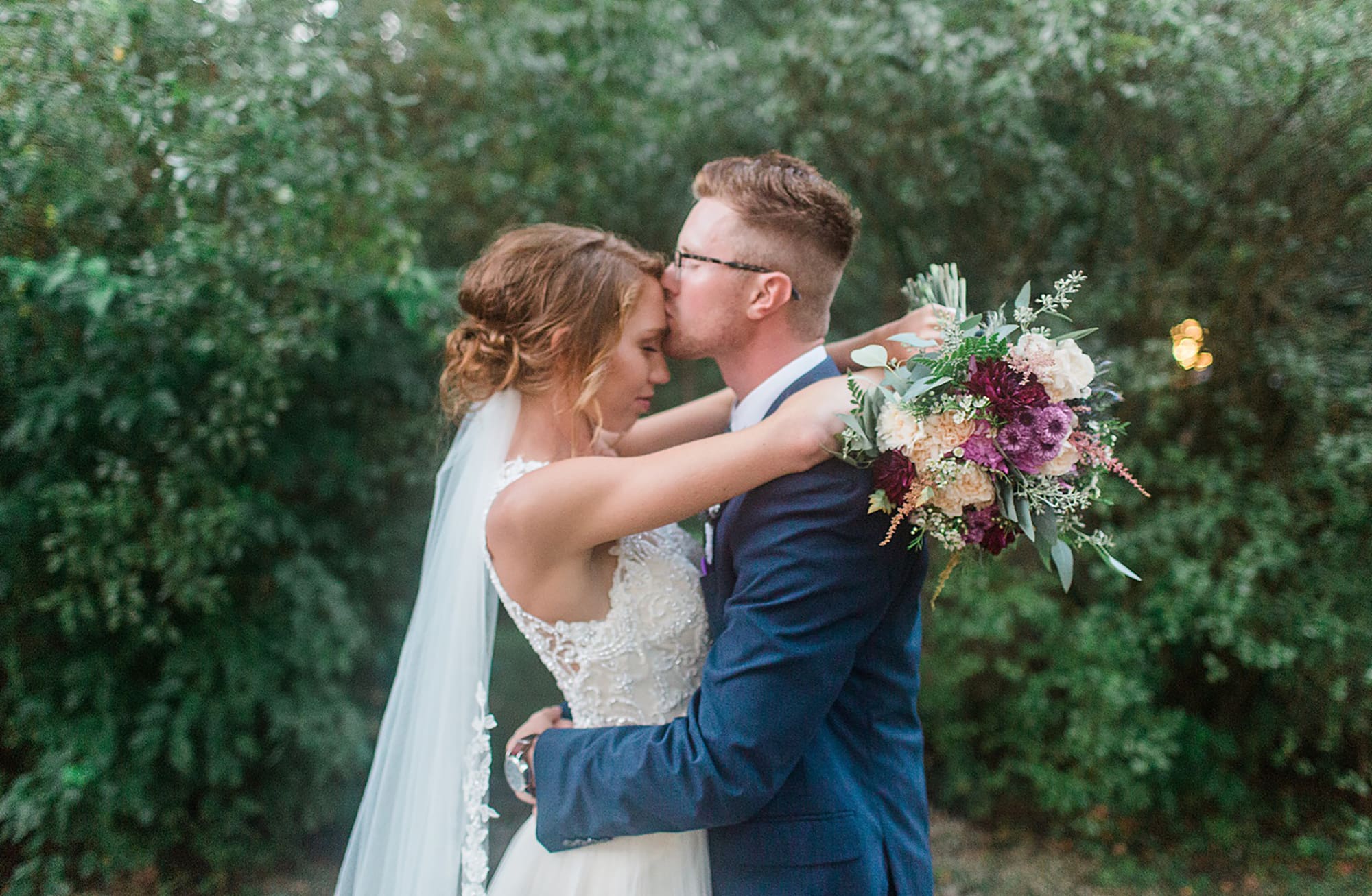 Arielle Peters Photography | Bride and groom kissing under tunnel of trees at outdoor wedding at Willowfield Lavender Farm in Mooresville, Indiana. 