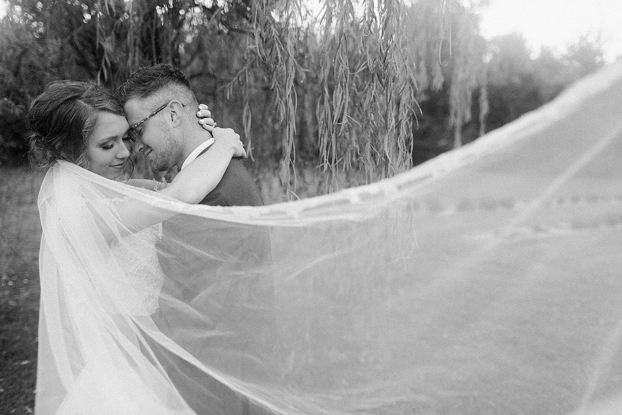 Arielle Peters Photography | Bride and groom hugging under willow tree at outdoor wedding at Willowfield Lavender Farm in Mooresville, Indiana. 