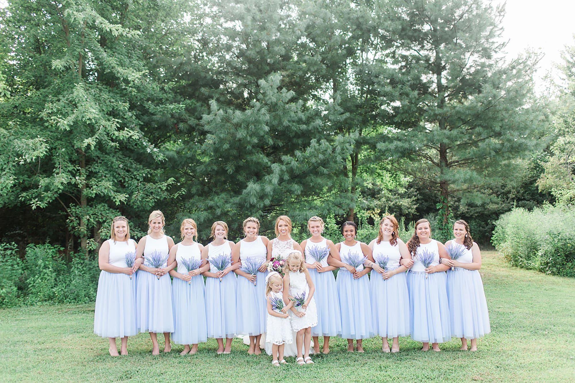 Arielle Peters Photography | Bride and bridesmaids next to large trees on wedding day at Willowfield Lavender Farm in Mooresville, Indiana. 