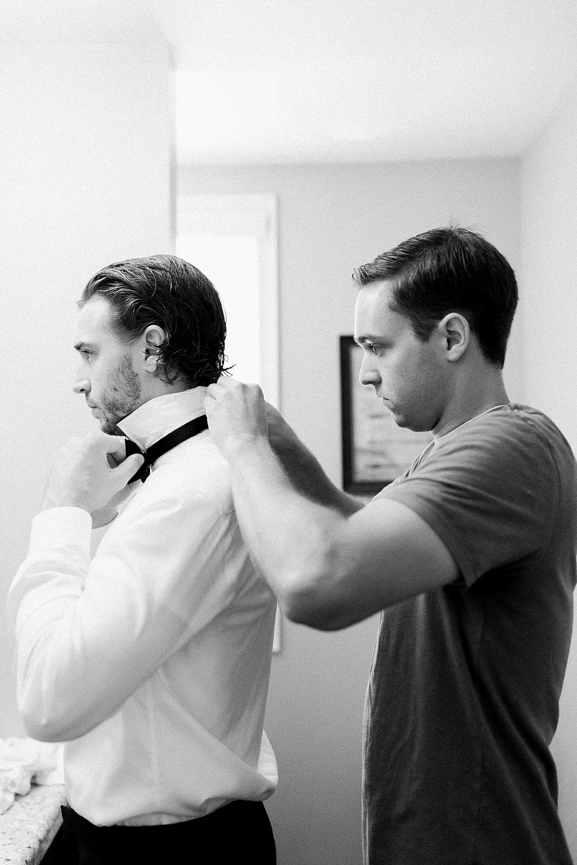 Arielle Peters Photography | Groom putting on his bowtie on wedding day at the Uptown Center in Michigan City, Indiana.