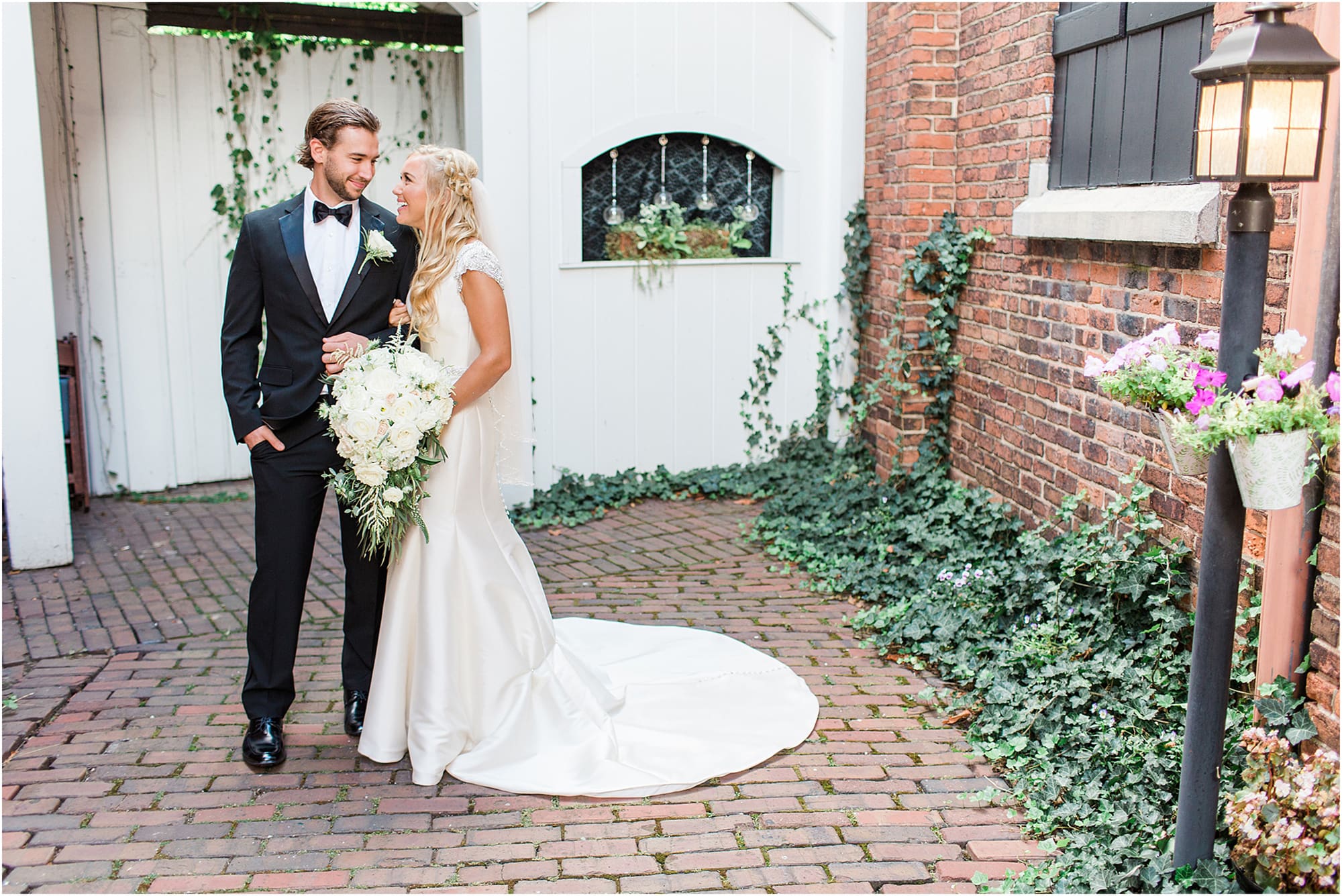Arielle Peters Photography | Bride and groom next to ivy-covered bricks on wedding day at the Uptown Center in Michigan City, Indiana.