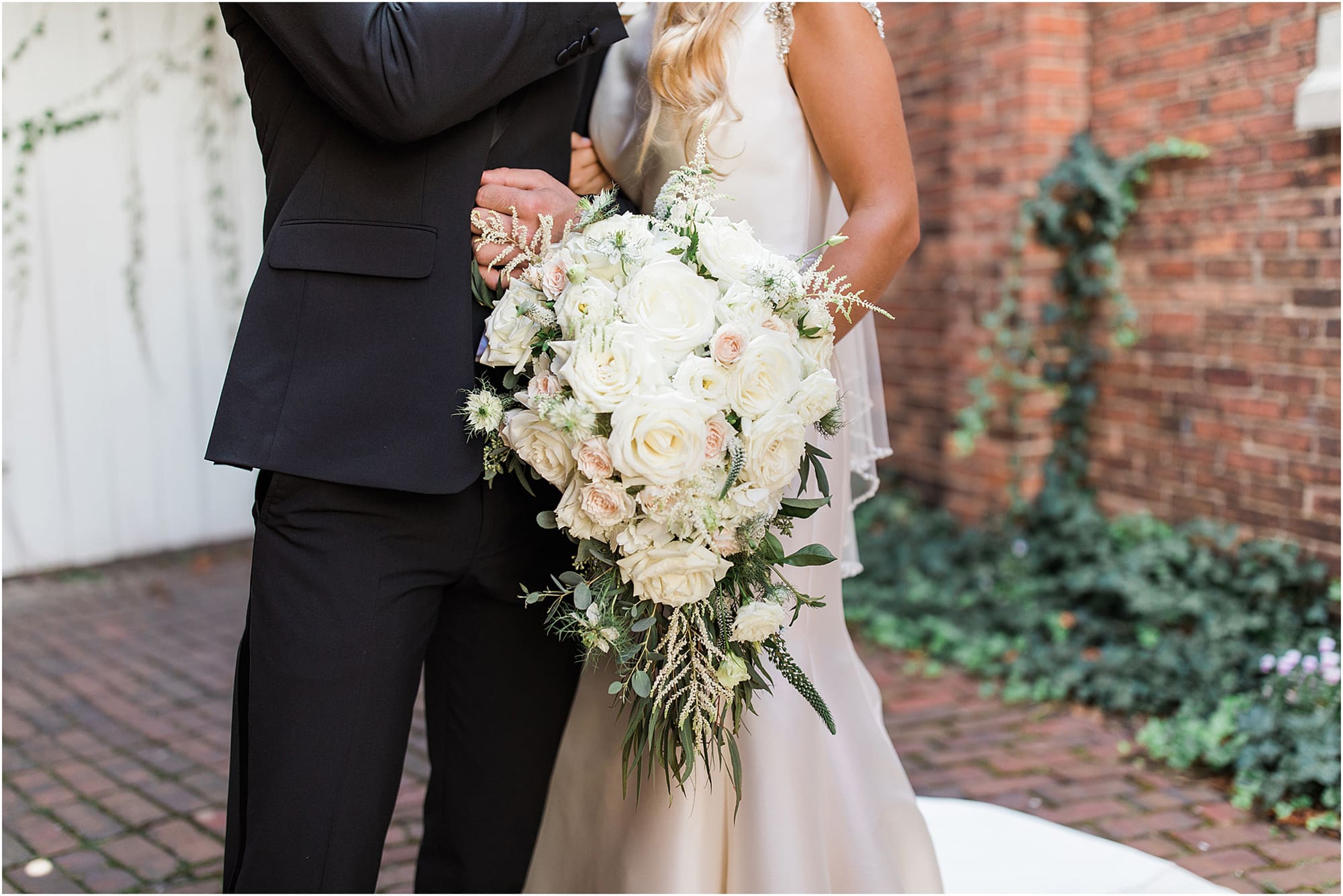 Arielle Peters Photography | Bride and groom next to ivy-covered bricks on wedding day at the Uptown Center in Michigan City, Indiana.