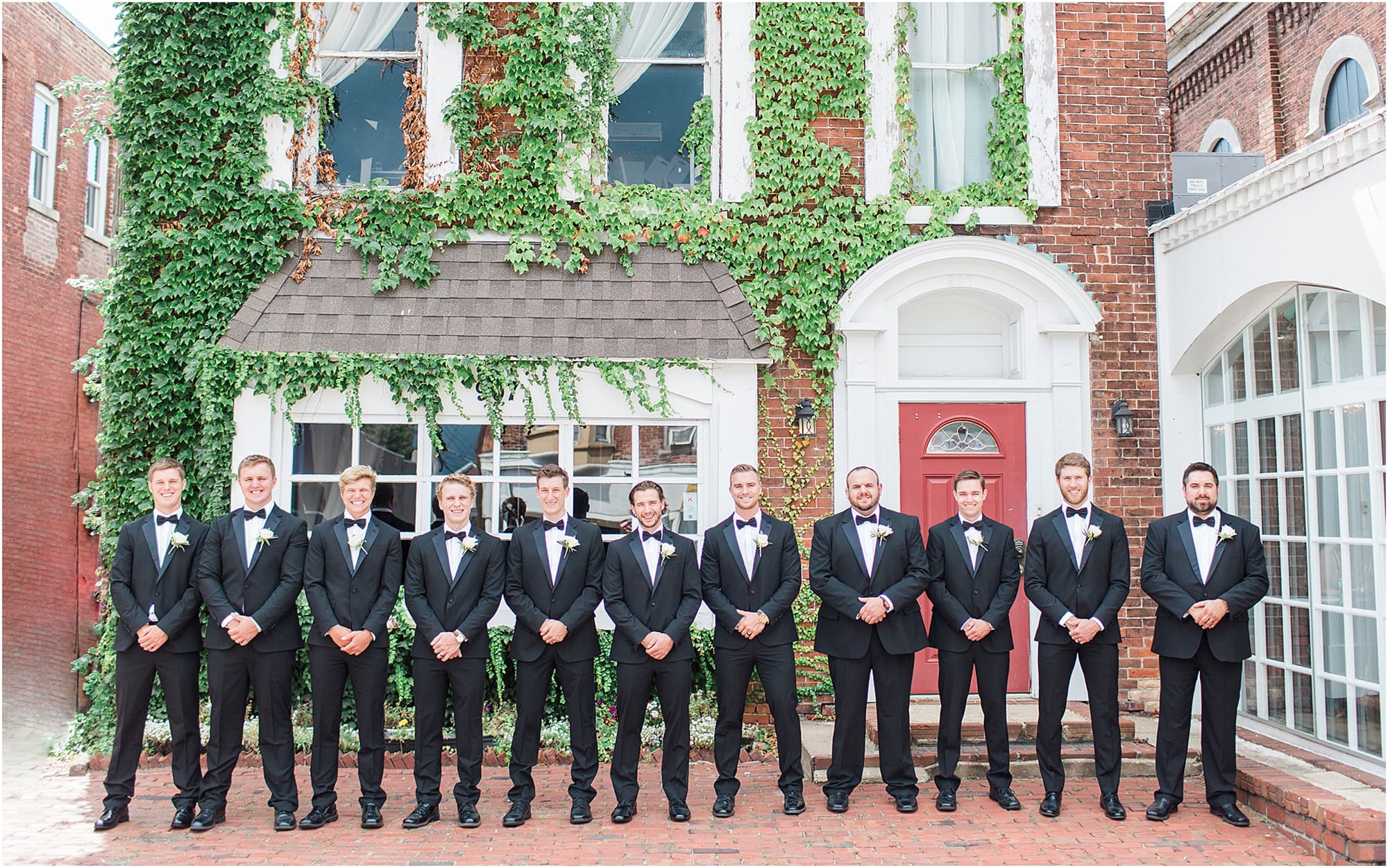 Arielle Peters Photography | Groom and groomsmen next to ivy-covered building on wedding day at the Uptown Center in Michigan City, Indiana.