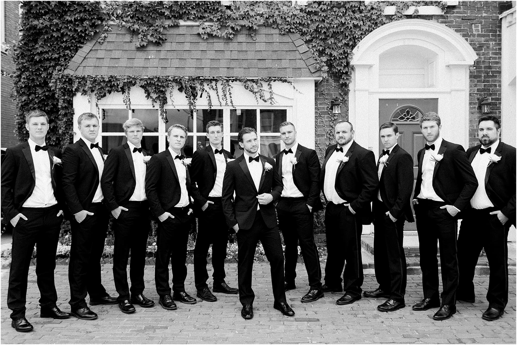 Arielle Peters Photography | Groom and groomsmen next to ivy-covered building on wedding day at the Uptown Center in Michigan City, Indiana.