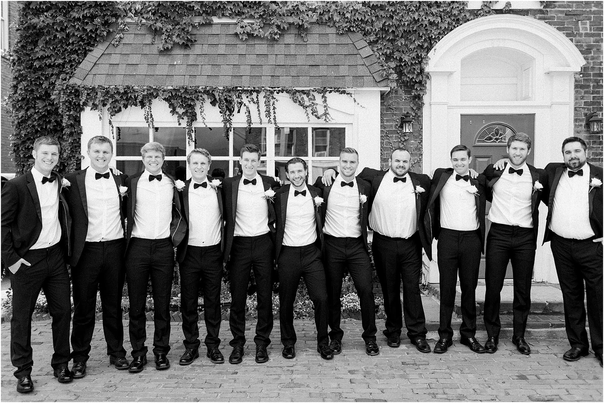 Arielle Peters Photography | Groom and groomsmen next to ivy-covered building on wedding day at the Uptown Center in Michigan City, Indiana.