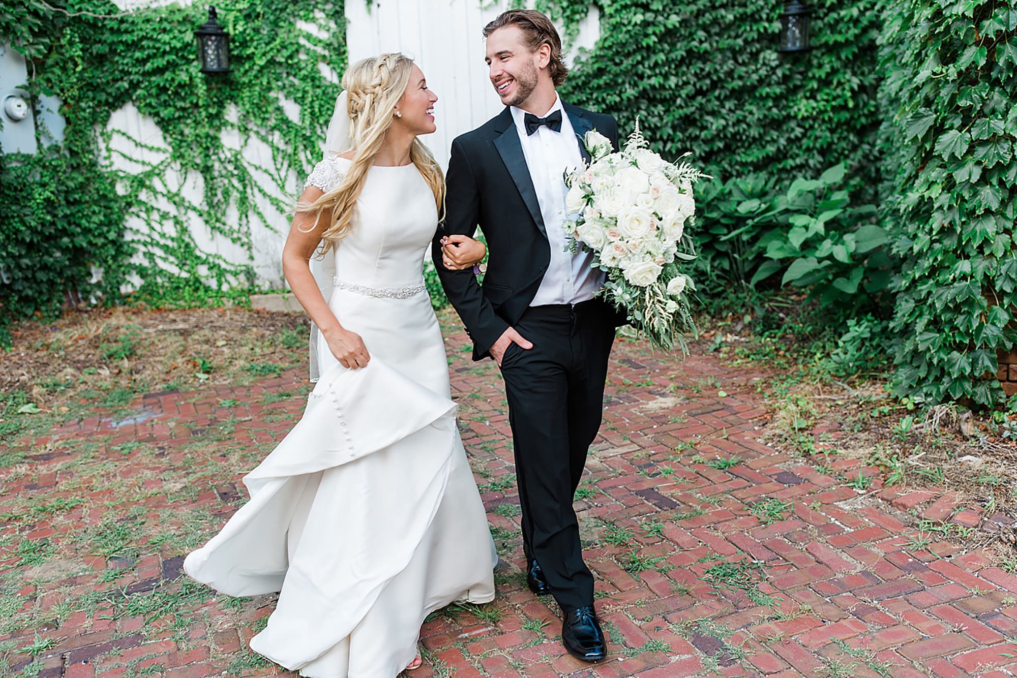 Arielle Peters Photography | Bride and groom walking next to ivy-covered walls on wedding day at the Uptown Center in Michigan City, Indiana.
