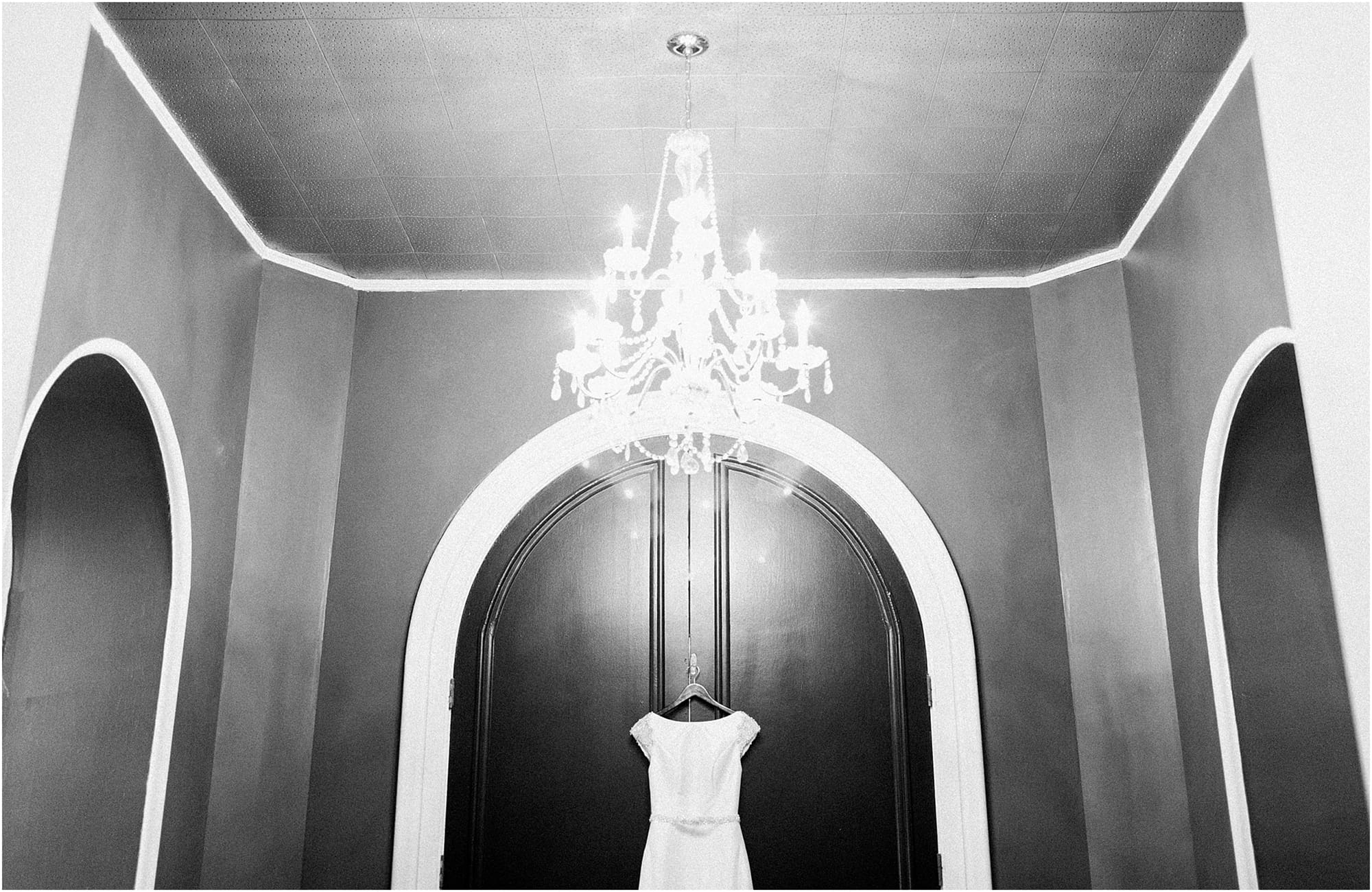 Arielle Peters Photography | Wedding dress hanging on large wooden door on wedding day at the Uptown Center in Michigan City, Indiana.