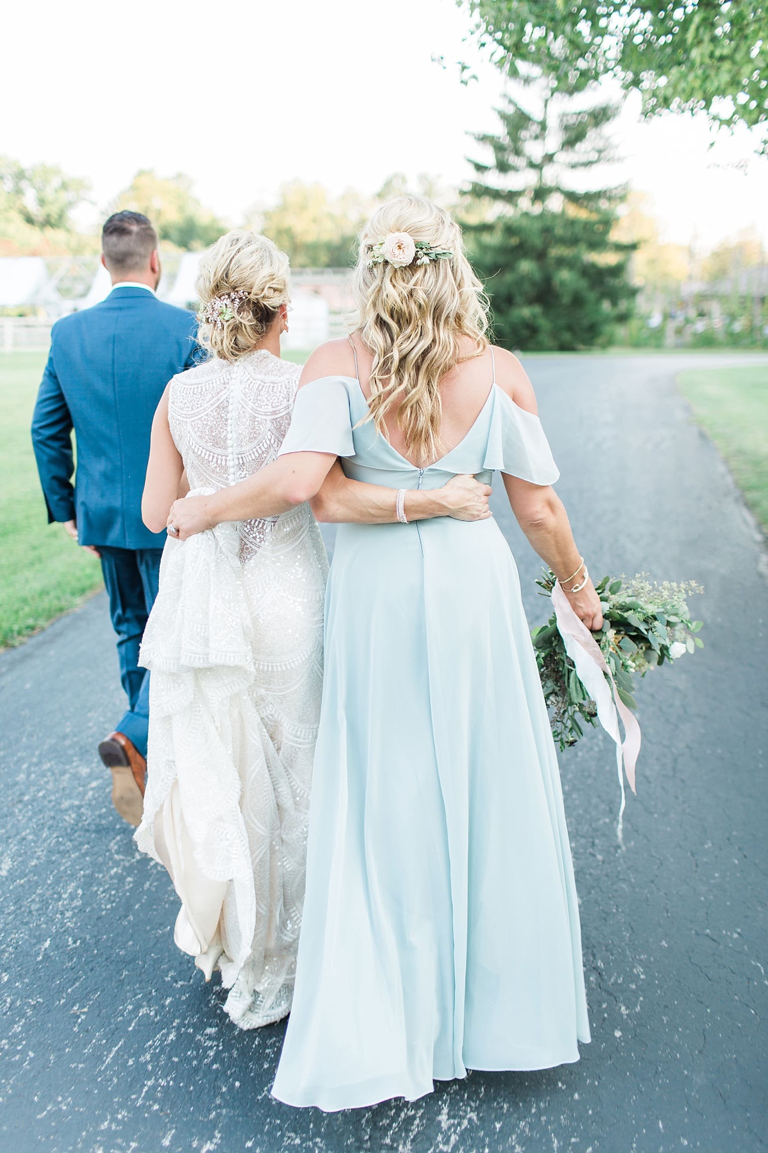 Arielle Peters Photography | Bride and bridesmaid walking together on wedding day at Joseph Decuis Farm in Roanoke, Indiana.
