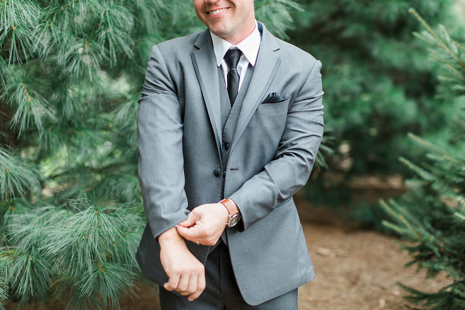 Arielle Peters Photography | Groom standing by tall pine trees on wedding day at The Pavilion at Sandy Pines in Demotte, Indiana.