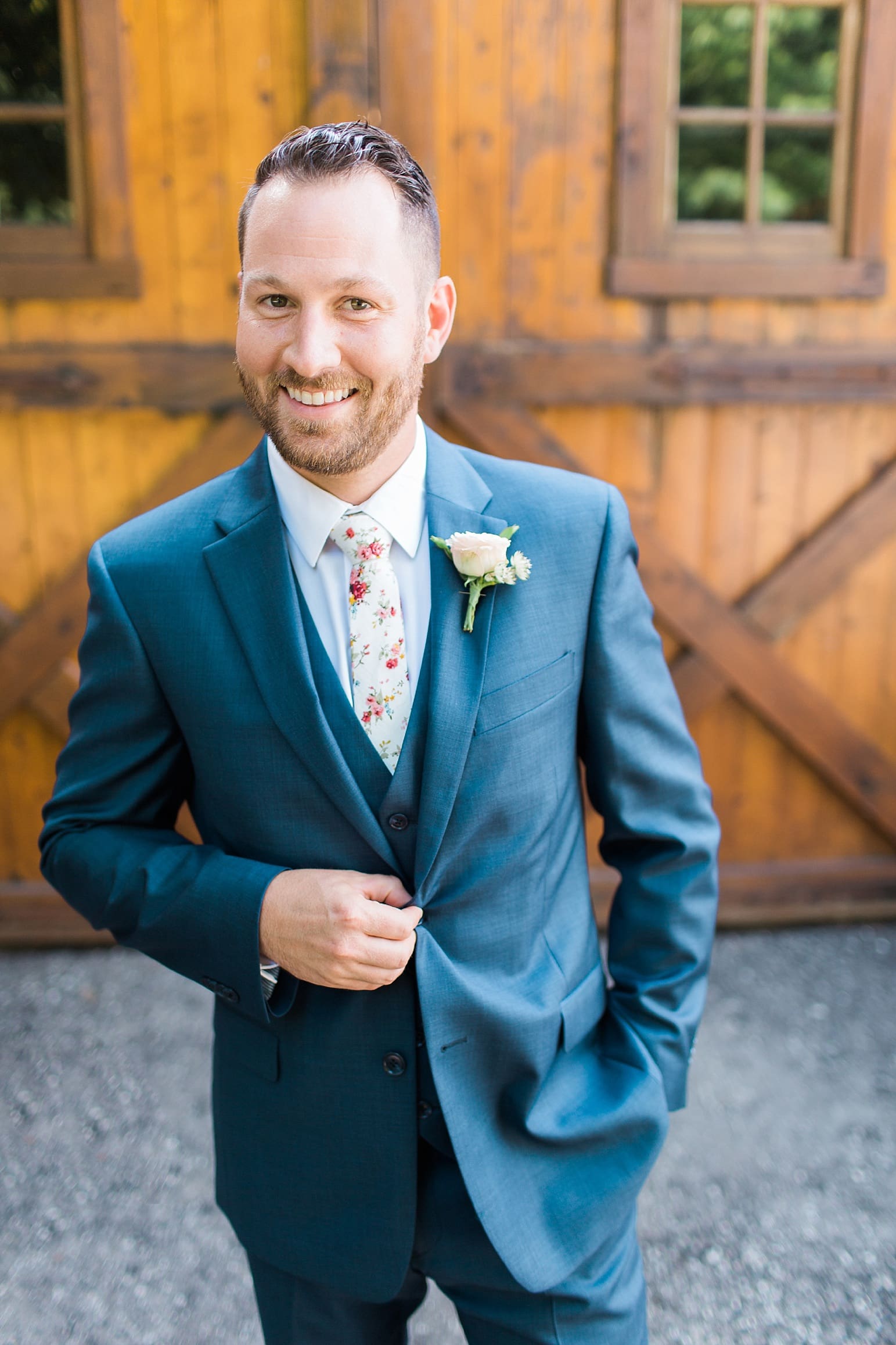 Arielle Peters Photography | Groom in front of wooden barn door on street on wedding day at Joseph Decuis Farm in Roanoke, Indiana.