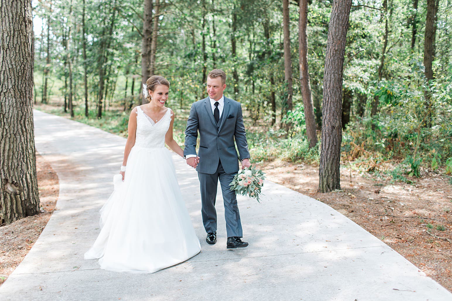 Arielle Peters Photography | Bride and groom walking in pine tree forest on wedding day at The Pavilion at Sandy Pines in Demotte, Indiana.