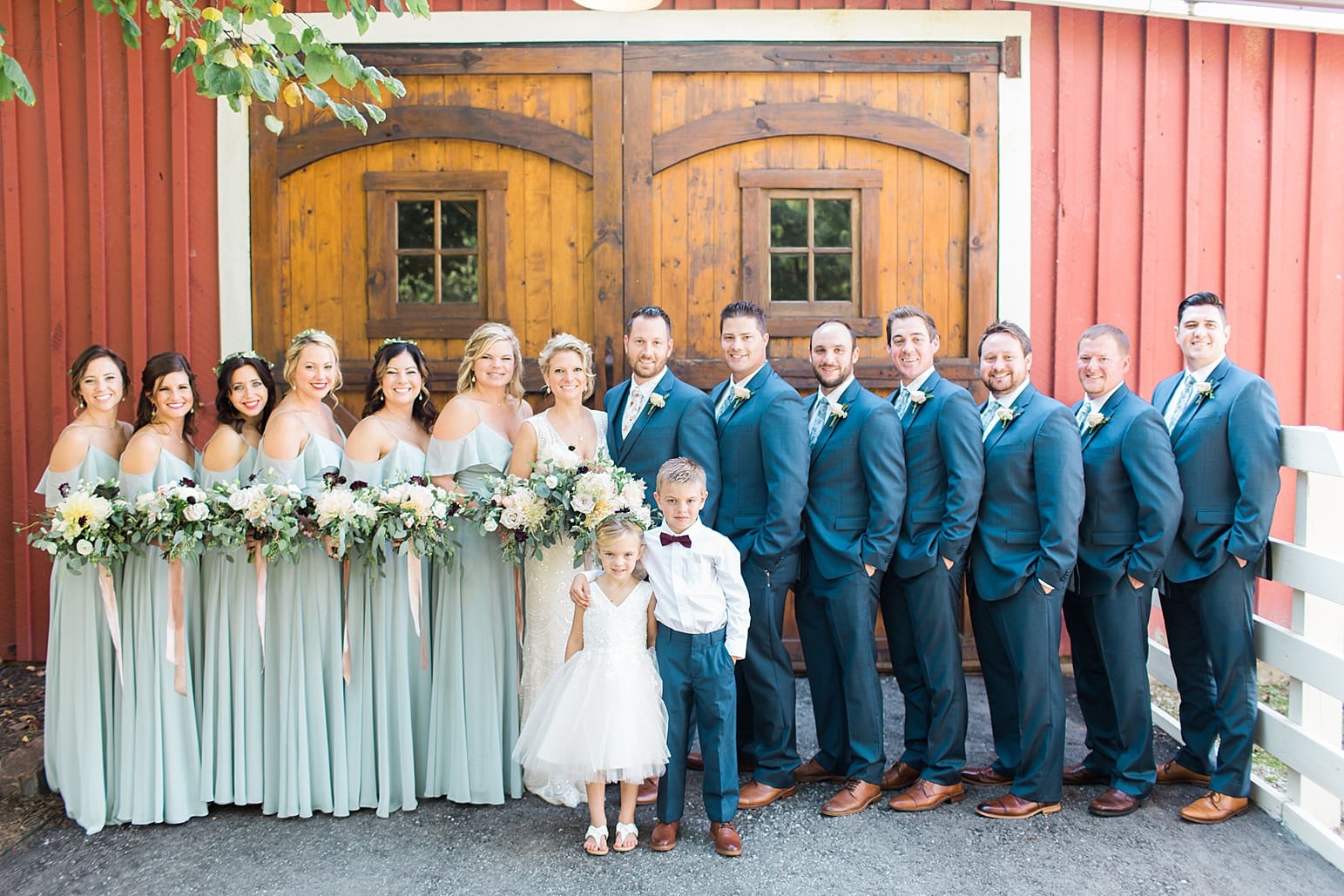 Arielle Peters Photography | Wedding party standing in front of wood barn doors on wedding day at Joseph Decuis Farm in Roanoke, Indiana.