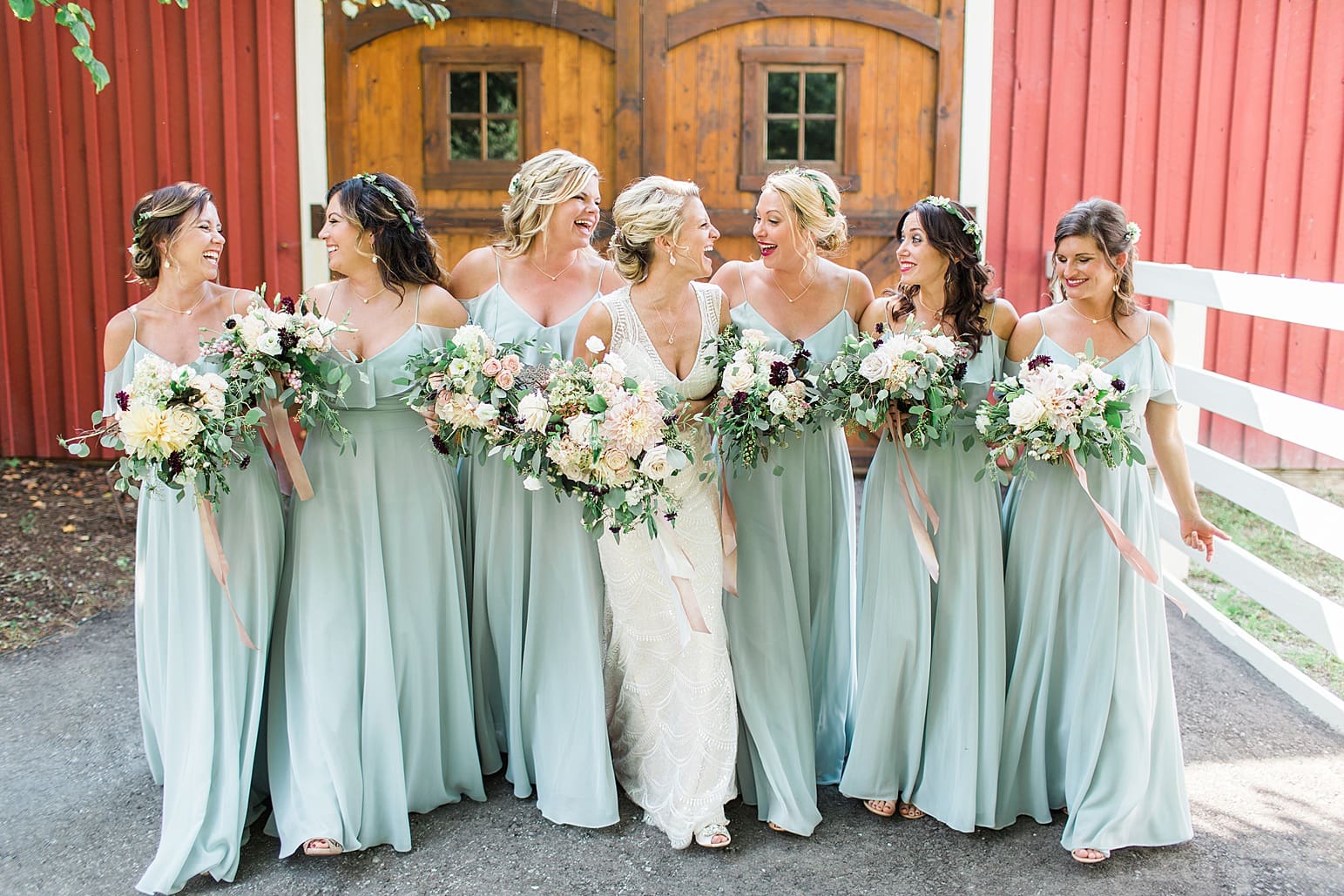 Arielle Peters Photography | Bride and bridesmaids in front of wooden barn door on wedding day at Joseph Decuis Farm in Roanoke, Indiana.