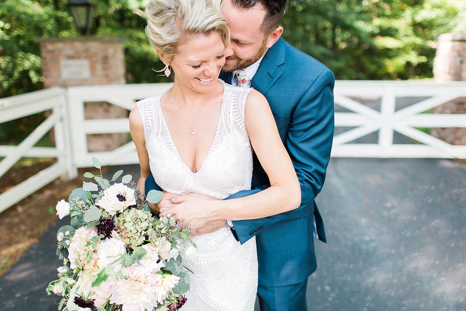 Arielle Peters Photography | Bride and groom hugging in front of white fence on wedding day at Joseph Decuis Farm in Roanoke, Indiana.