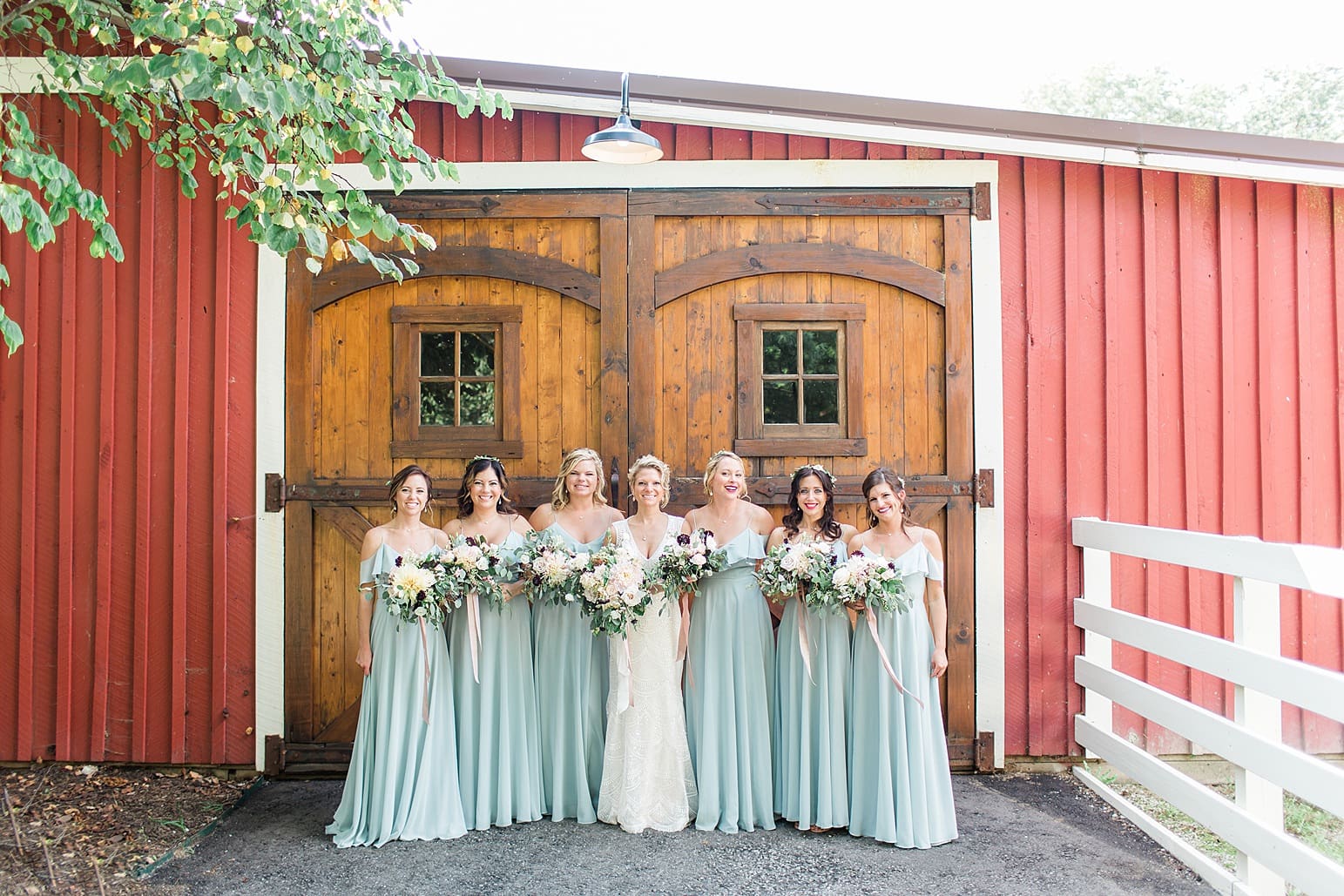 Arielle Peters Photography | Bride and bridesmaids in front of wooden barn door on wedding day at Joseph Decuis Farm in Roanoke, Indiana.