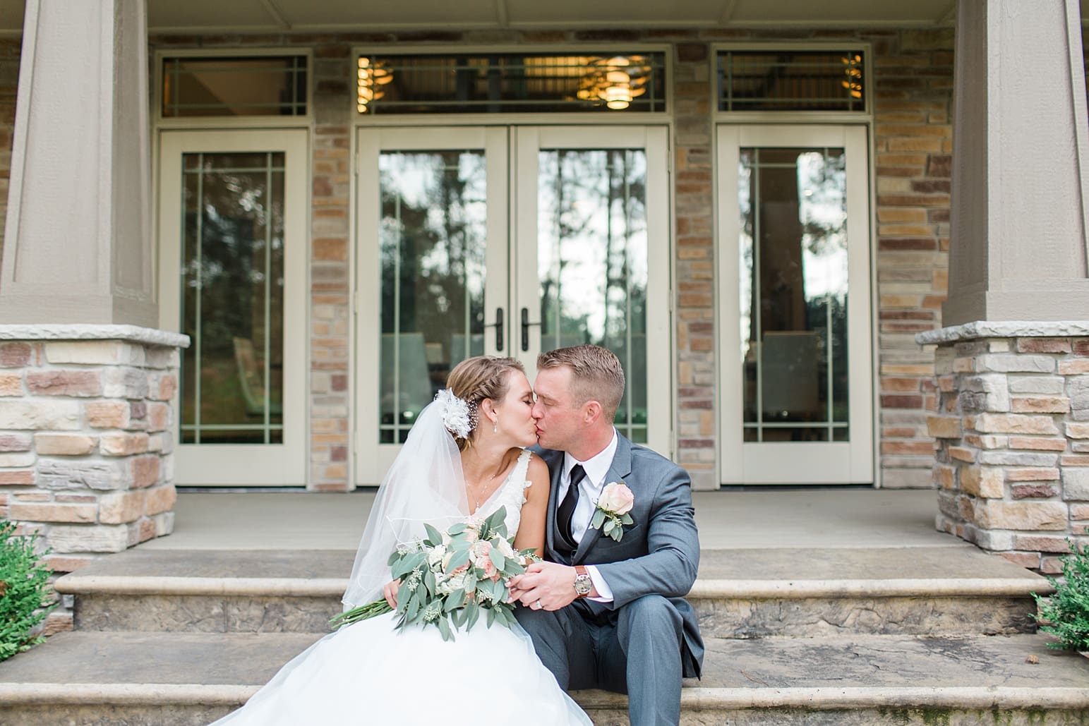 Arielle Peters Photography | Bride and groom kissing on steps on wedding day at The Pavilion at Sandy Pines in Demotte, Indiana.