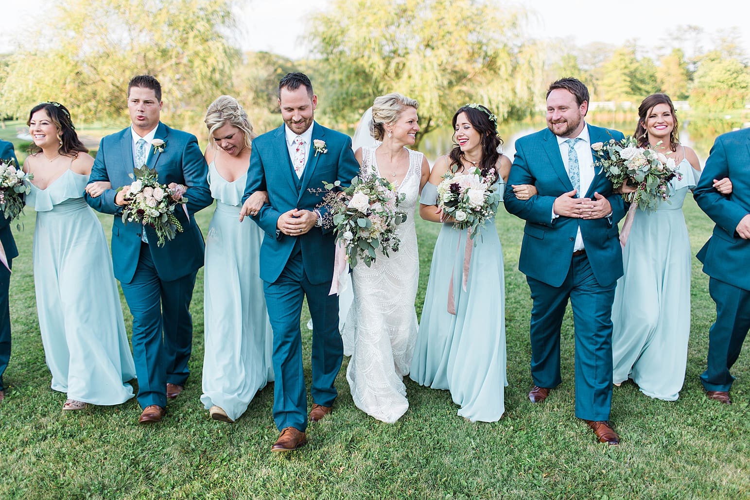 Arielle Peters Photography | Wedding party walking in open field next to pond on wedding day at Joseph Decuis Farm in Roanoke, Indiana.
