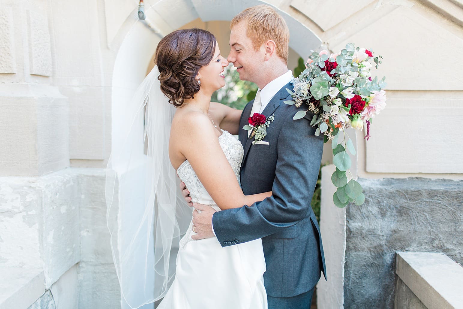 Arielle Peters Photography | Bride and groom almost kissing outside limestone church on fall wedding day in Winona Lake, Indiana.
