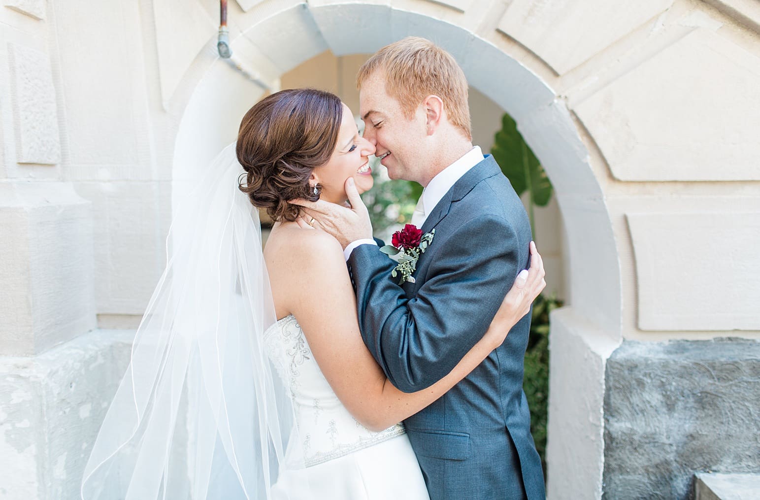 Arielle Peters Photography | Bride and groom almost kissing outside limestone church on fall wedding day in Winona Lake, Indiana.
