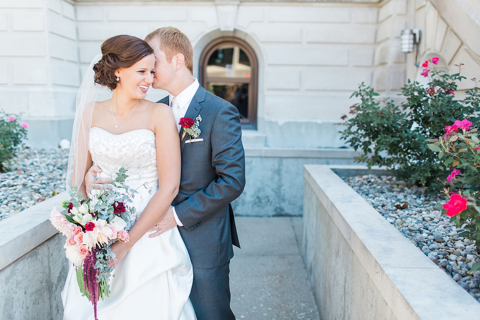 Arielle Peters Photography | Bride and groom kissing outside limestone church on fall wedding day in Winona Lake, Indiana.