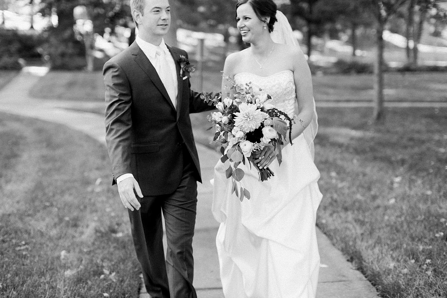 Arielle Peters Photography | Bride and groom walking through park on fall wedding day in Winona Lake, Indiana.