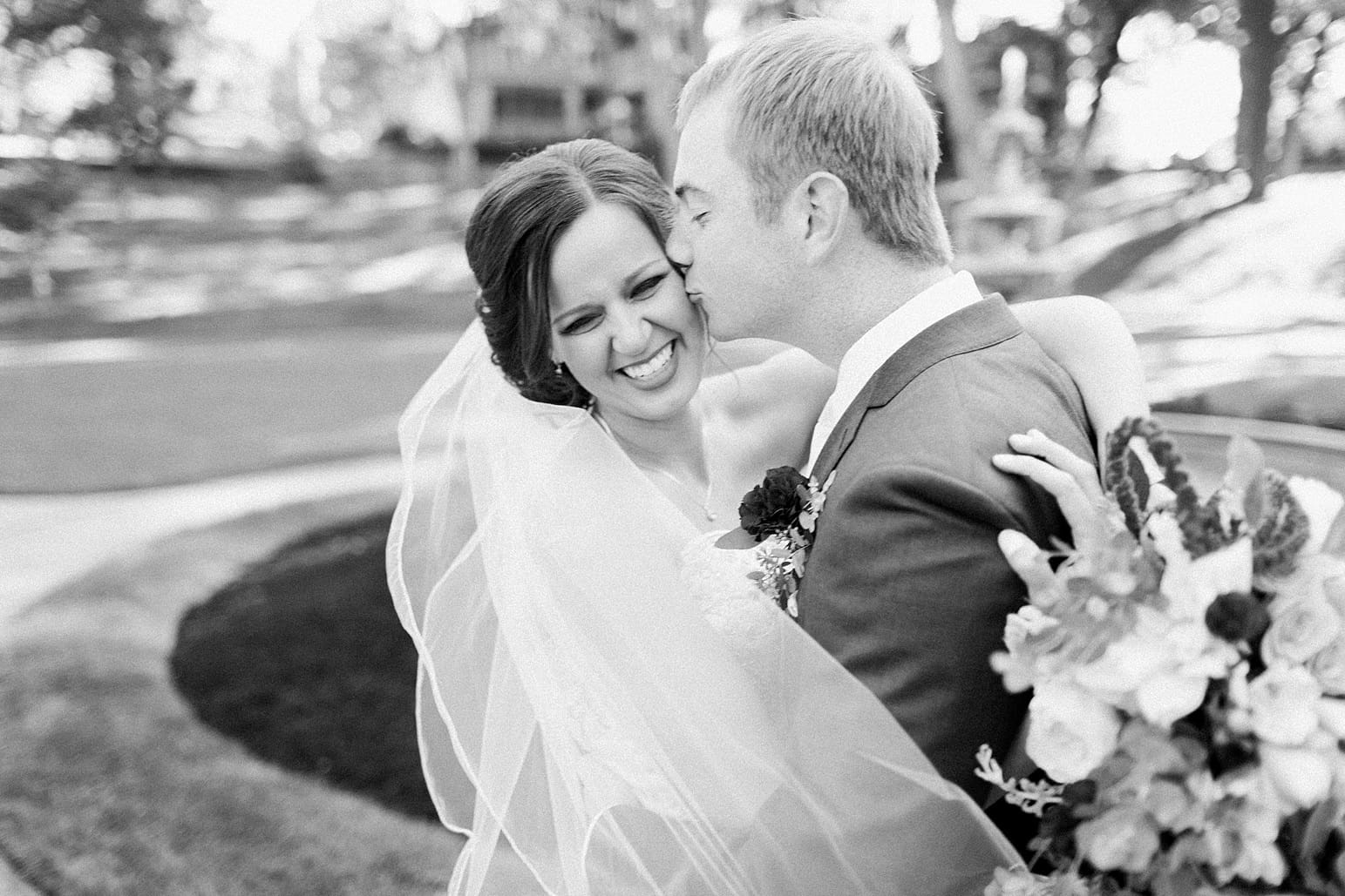 Arielle Peters Photography | Bride and groom kissing in park on fall wedding day in Winona Lake, Indiana.