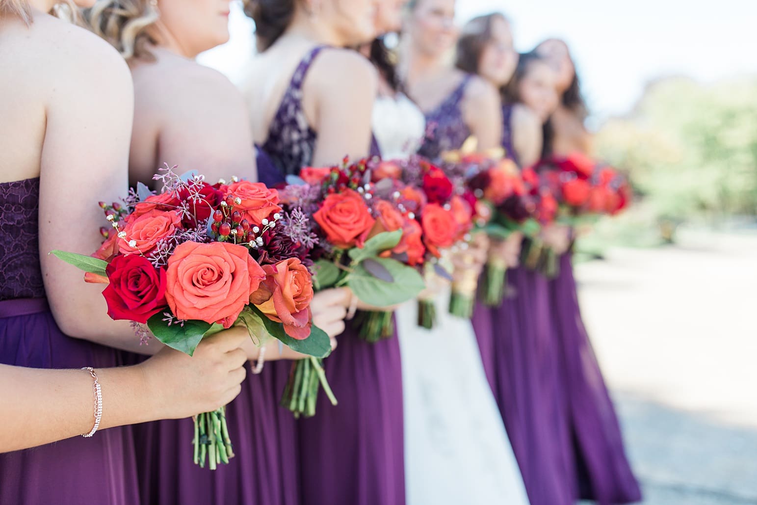 Arielle Peters Photography | Bride and bridesmaids holding bouquets on sidewalk on wedding day in Carmel, Indiana. 