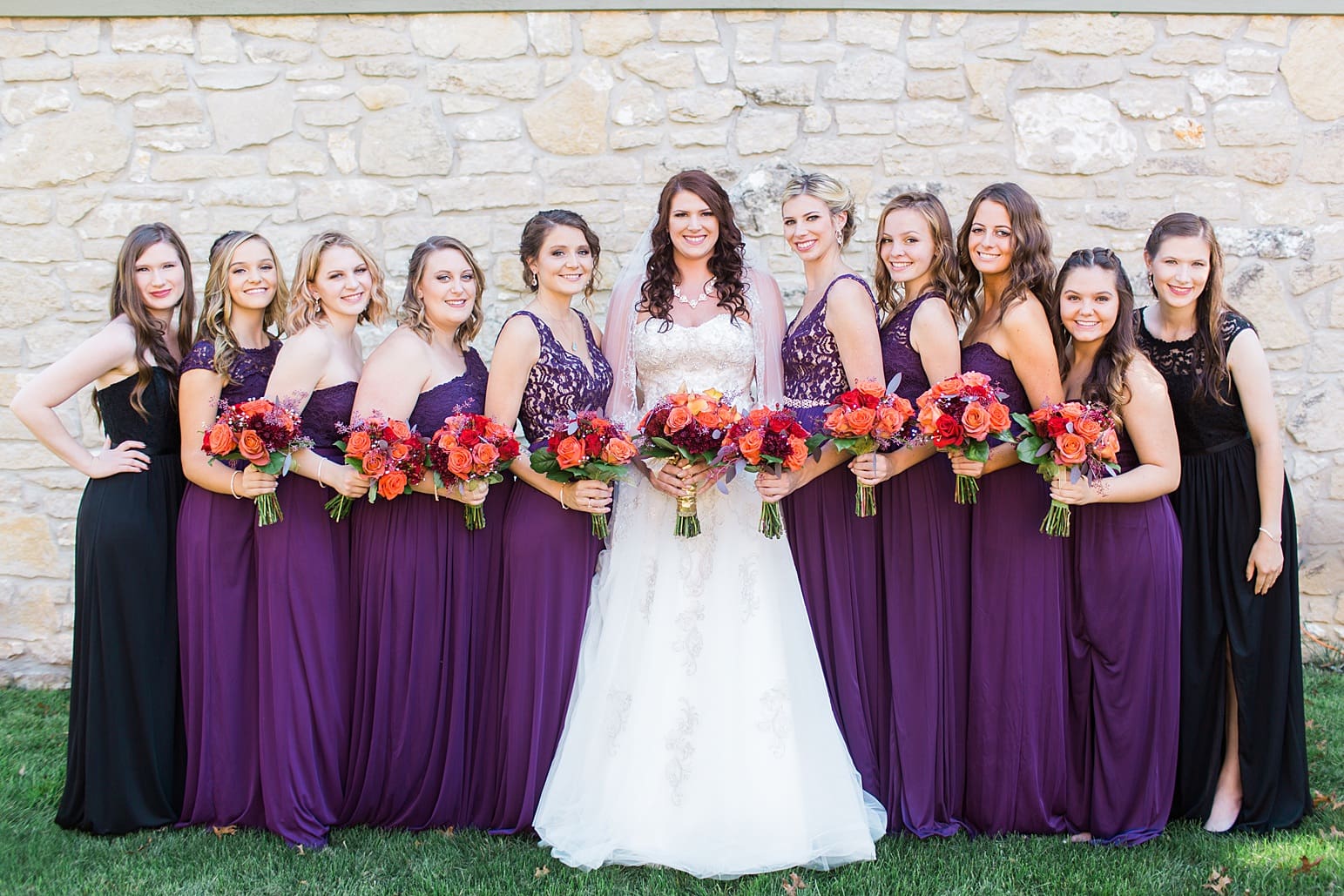 Arielle Peters Photography | Bride and bridesmaids next to limestone wall on wedding day in Carmel, Indiana. 