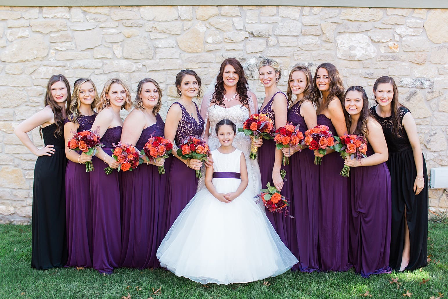 Arielle Peters Photography | Bride and bridesmaids next to limestone wall on wedding day in Carmel, Indiana. 