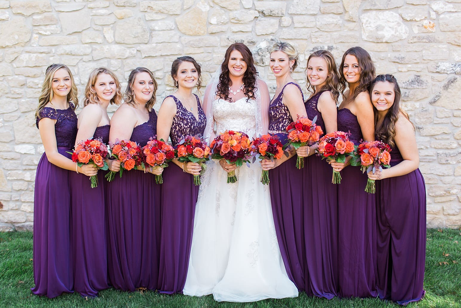 Arielle Peters Photography | Bride and bridesmaids next to limestone wall on wedding day in Carmel, Indiana. 