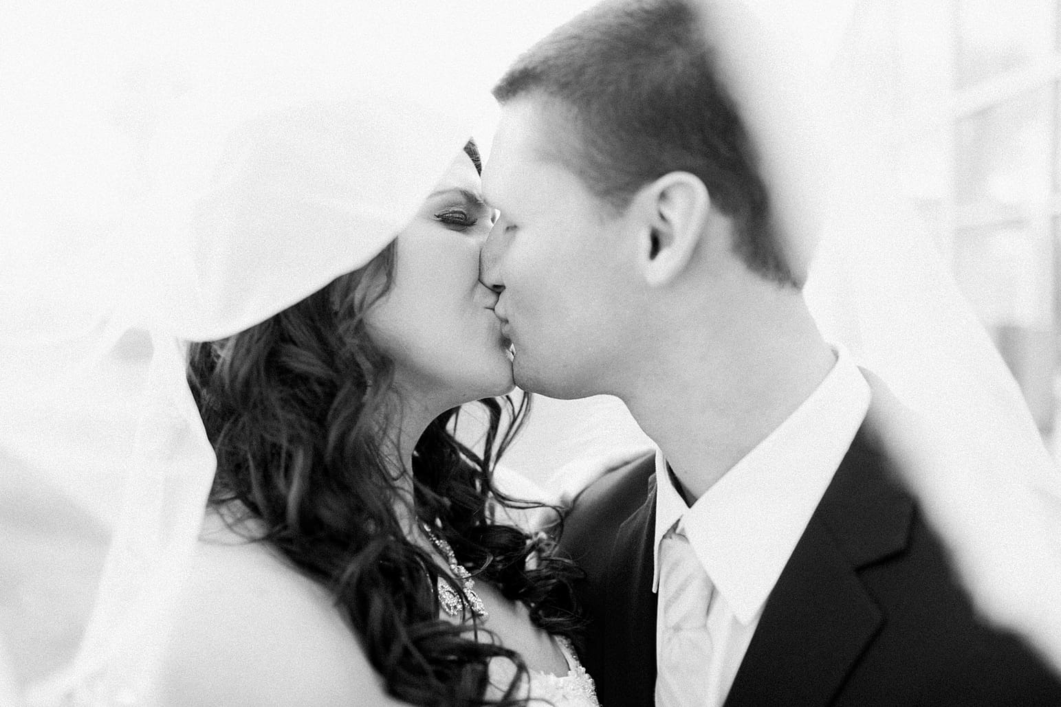 Arielle Peters Photography | Bride and groom kissing under veil on wedding day at the Ritz Charles Garden Pavilion in Carmel, Indiana. 