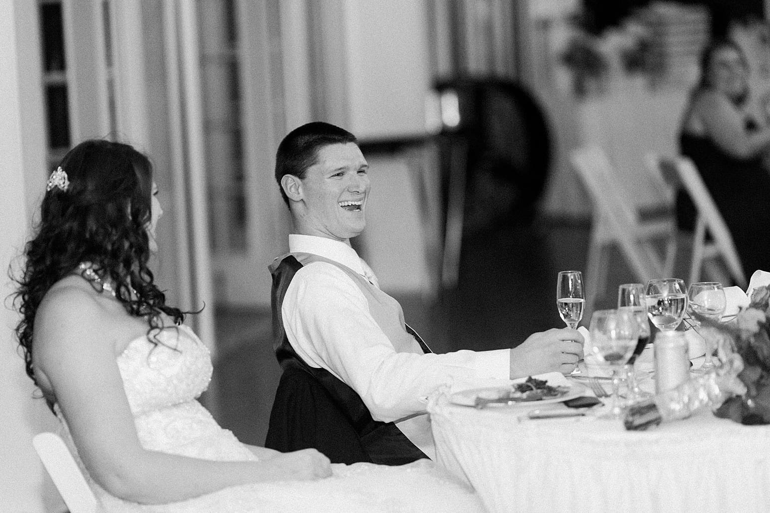 Arielle Peters Photography | Bride and groom laughing during speeches at wedding reception on wedding day at the Ritz Charles Garden Pavilion in Carmel, Indiana. 