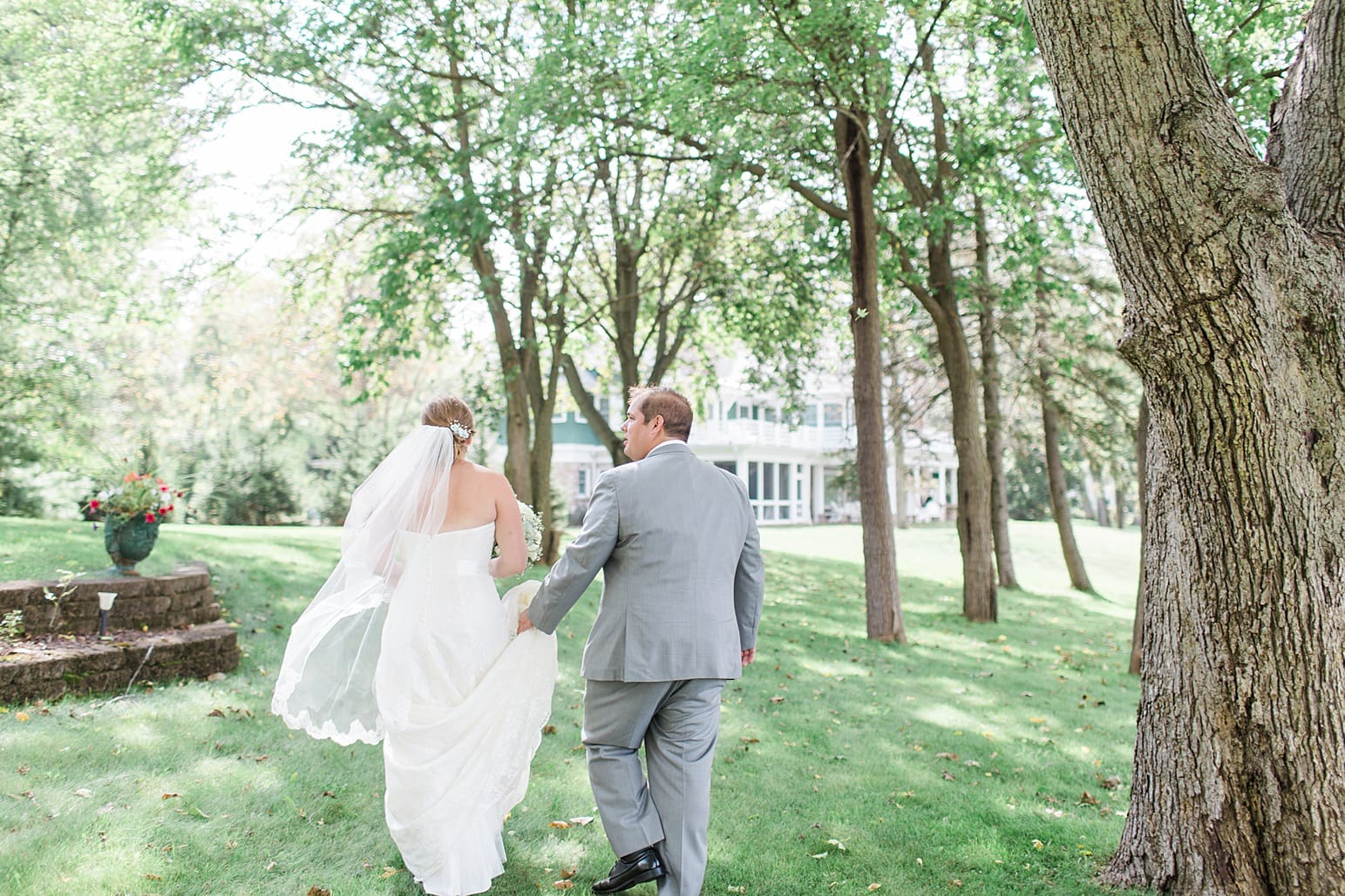 Arielle Peters Photography | Bride and groom walking in yard by lake on wedding day in Syracuse, Indiana.