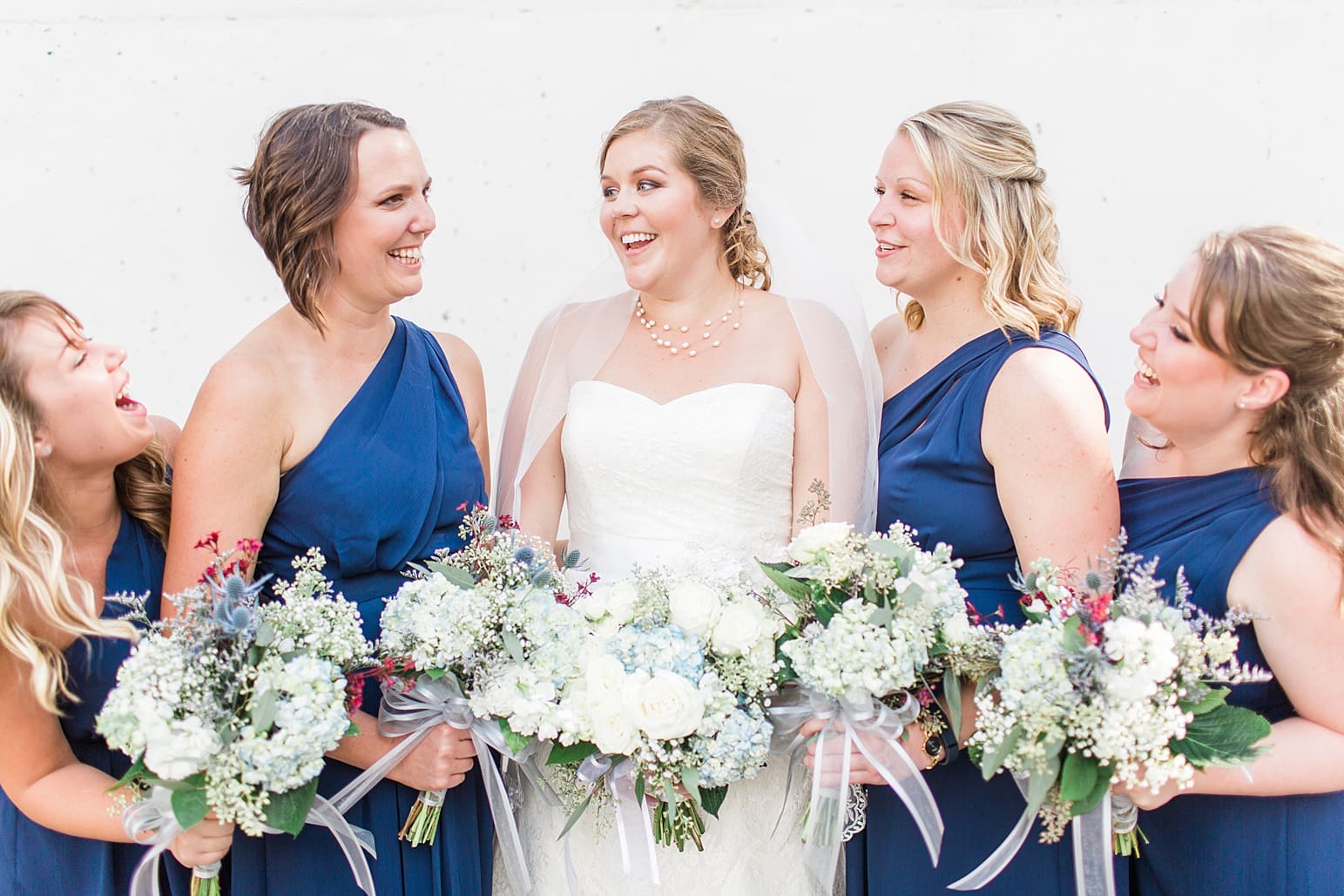 Arielle Peters Photography | Bride and bridesmaids holding bouquets outside on wedding day in Syracuse, Indiana.