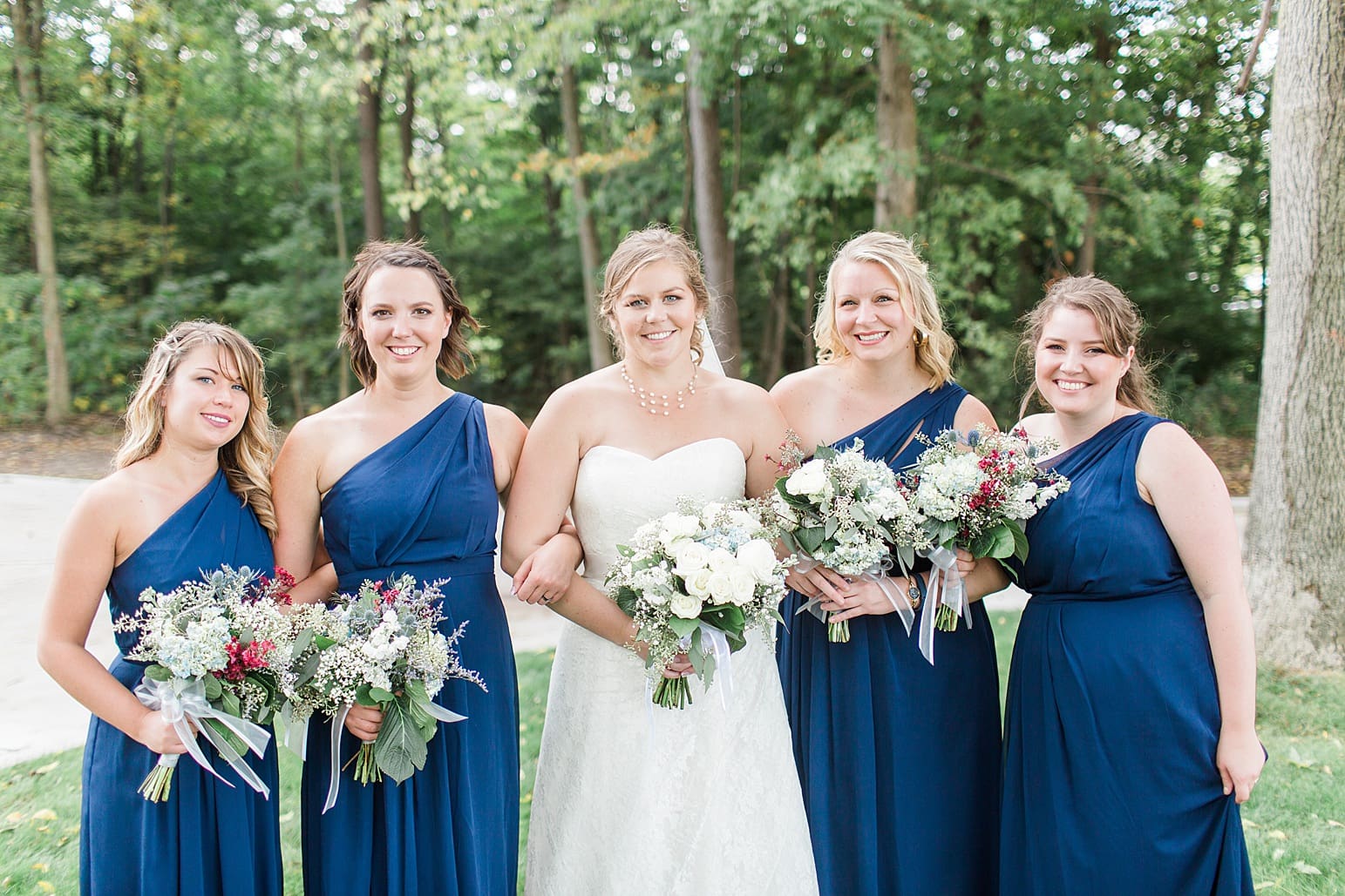 Arielle Peters Photography | Bride and bridesmaids outside under trees on wedding day in Syracuse, Indiana.