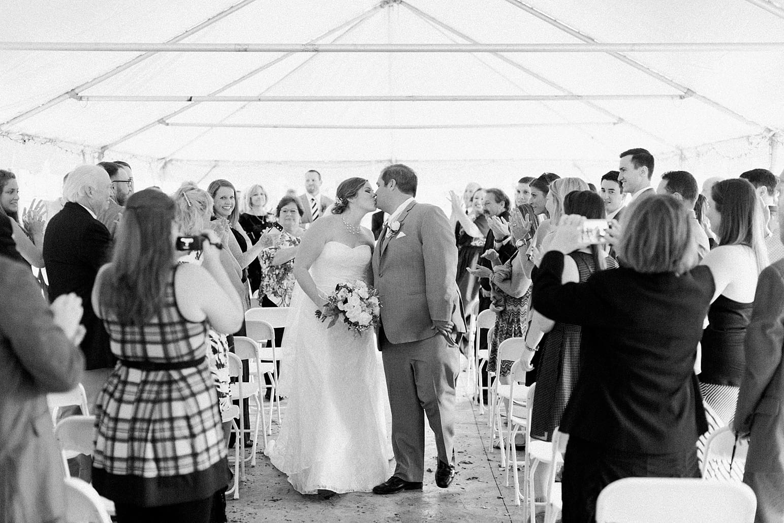 Arielle Peters Photography | Bride and groom kissing in the aisle on wedding day in Syracuse, Indiana.
