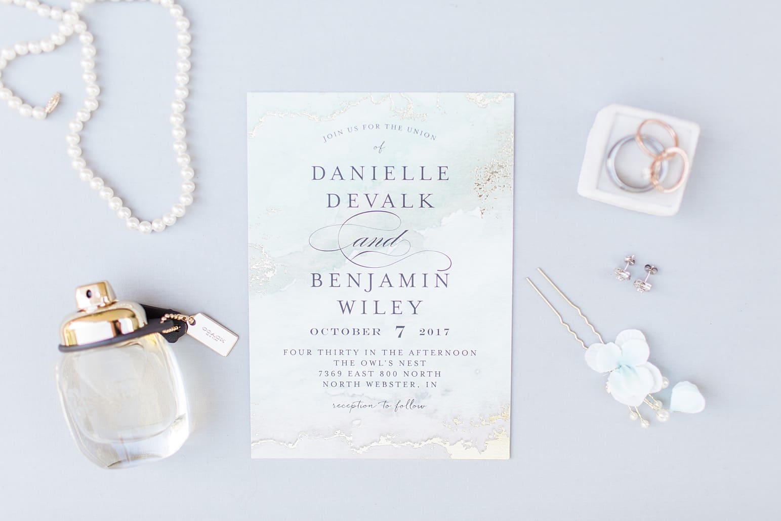 Arielle Peters Photography | Wedding invitation and jewelry on gray background on wedding day in Syracuse, Indiana.