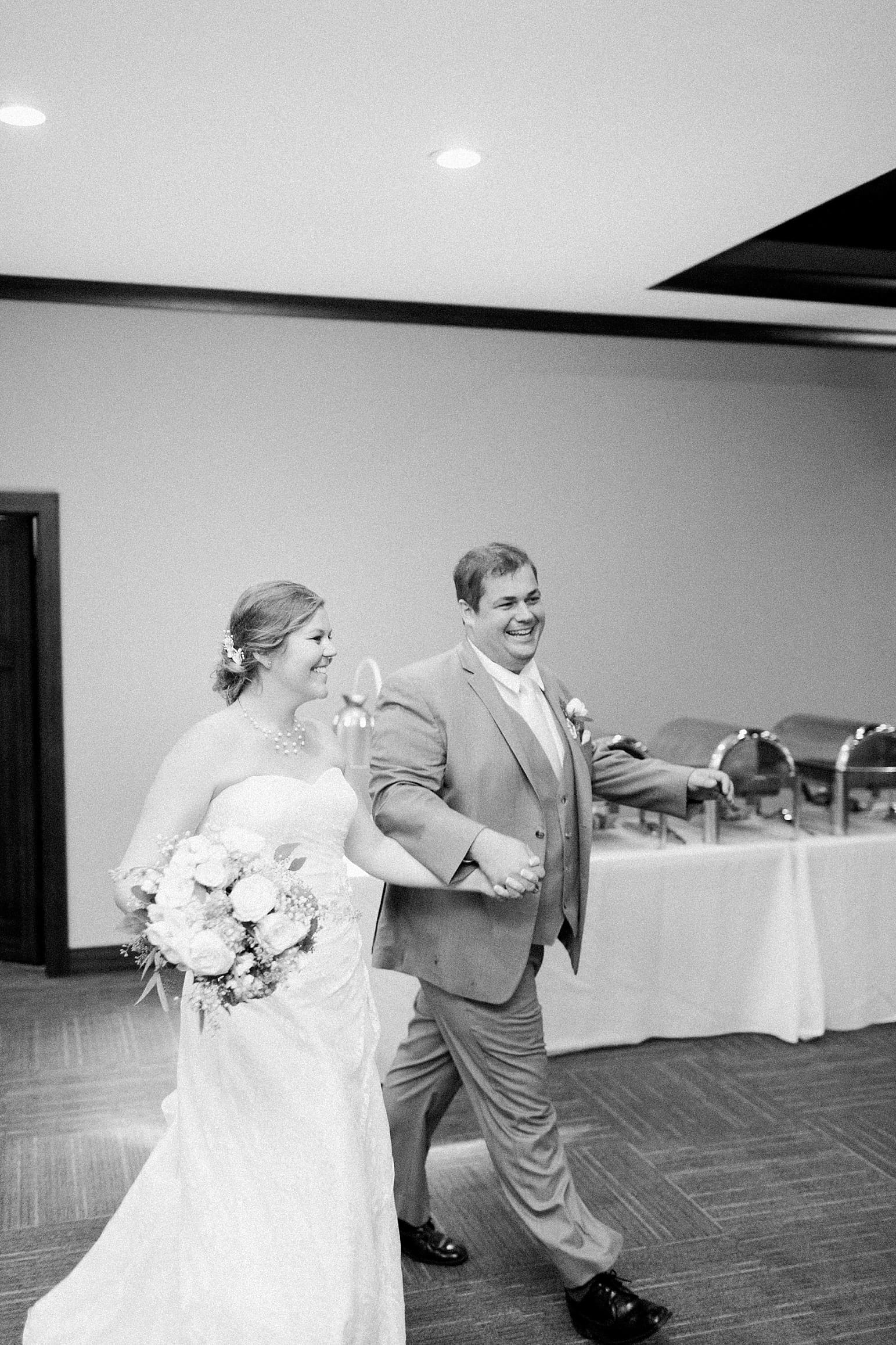 Arielle Peters Photography | Bride and groom entering wedding reception on wedding day at Sleepy Owl Restaurant in Syracuse, Indiana.