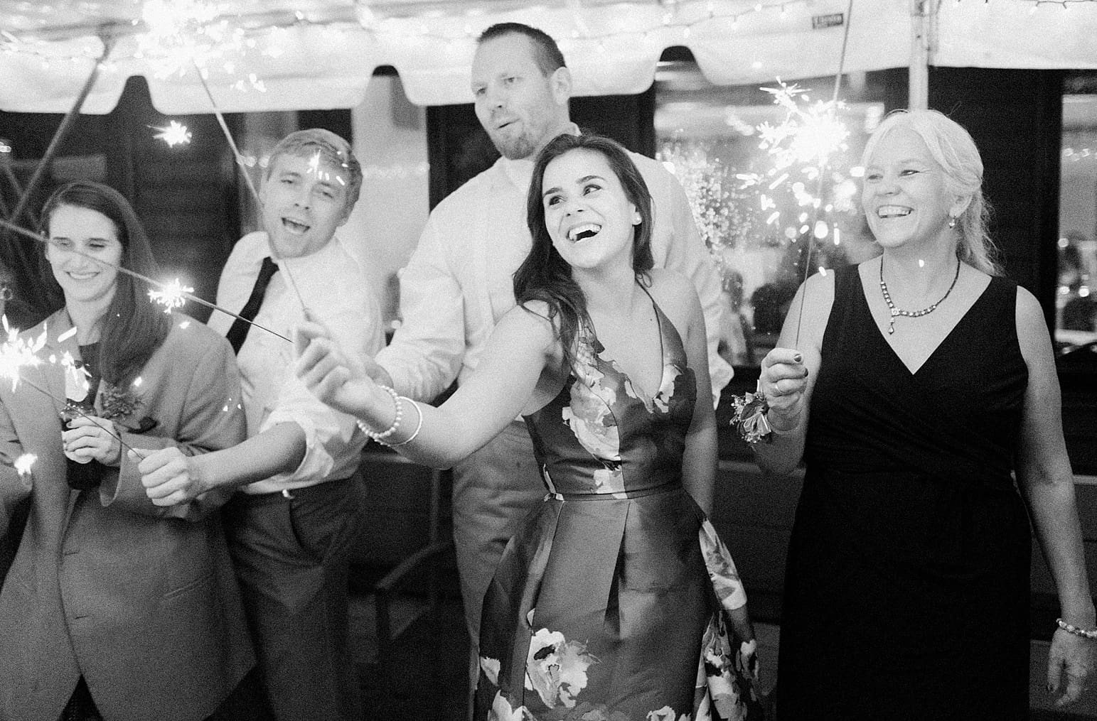 Arielle Peters Photography | Wedding guests holding sparklers on wedding day at Sleepy Owl Restaurant in Syracuse, Indiana.