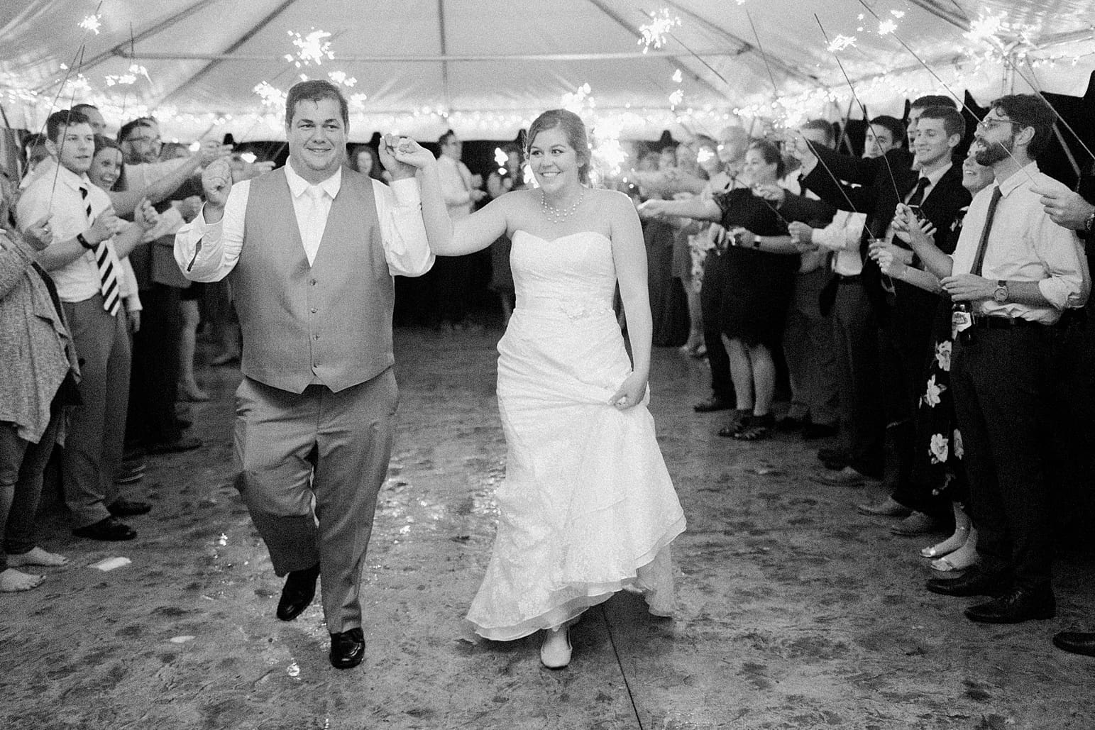 Arielle Peters Photography | Bride and groom walking through sparkler send off on wedding day at Sleepy Owl Restaurant in Syracuse, Indiana.