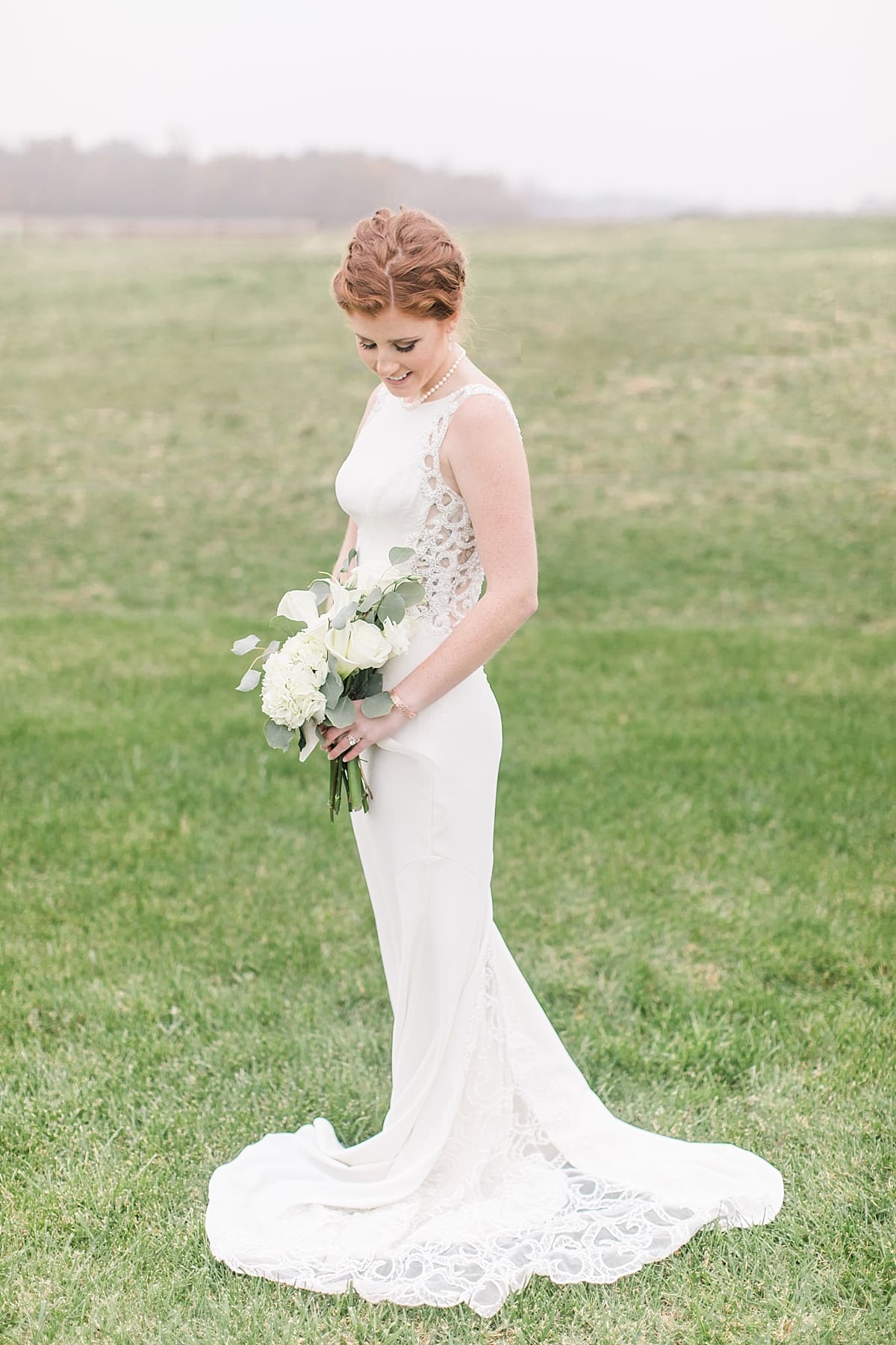 Arielle Peters Photography | Bride in open green field on gloomy wedding day in Huntington, Indiana.